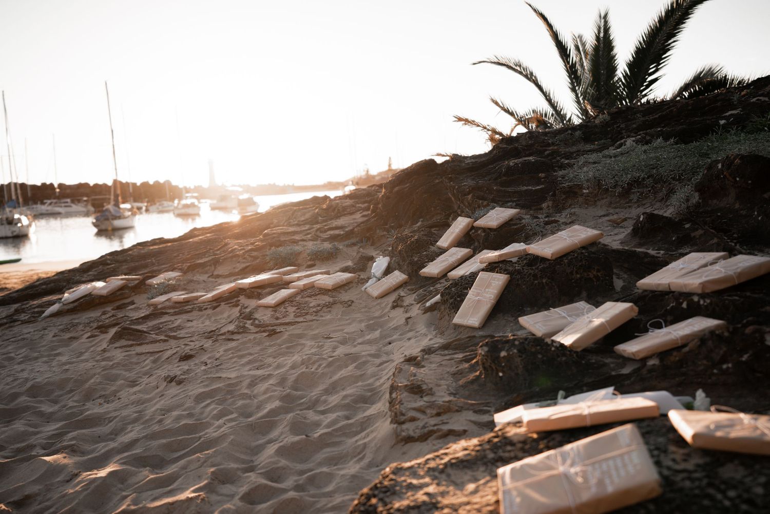 Rocky coastal shoreline with waves crashing against boulders at sunset.