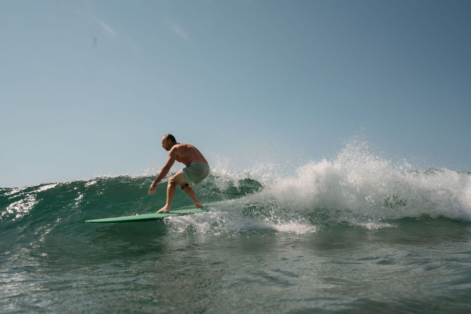 A sequence of surfing action shots shows a surfer riding turquoise waves on a shortboard during a sunny day.