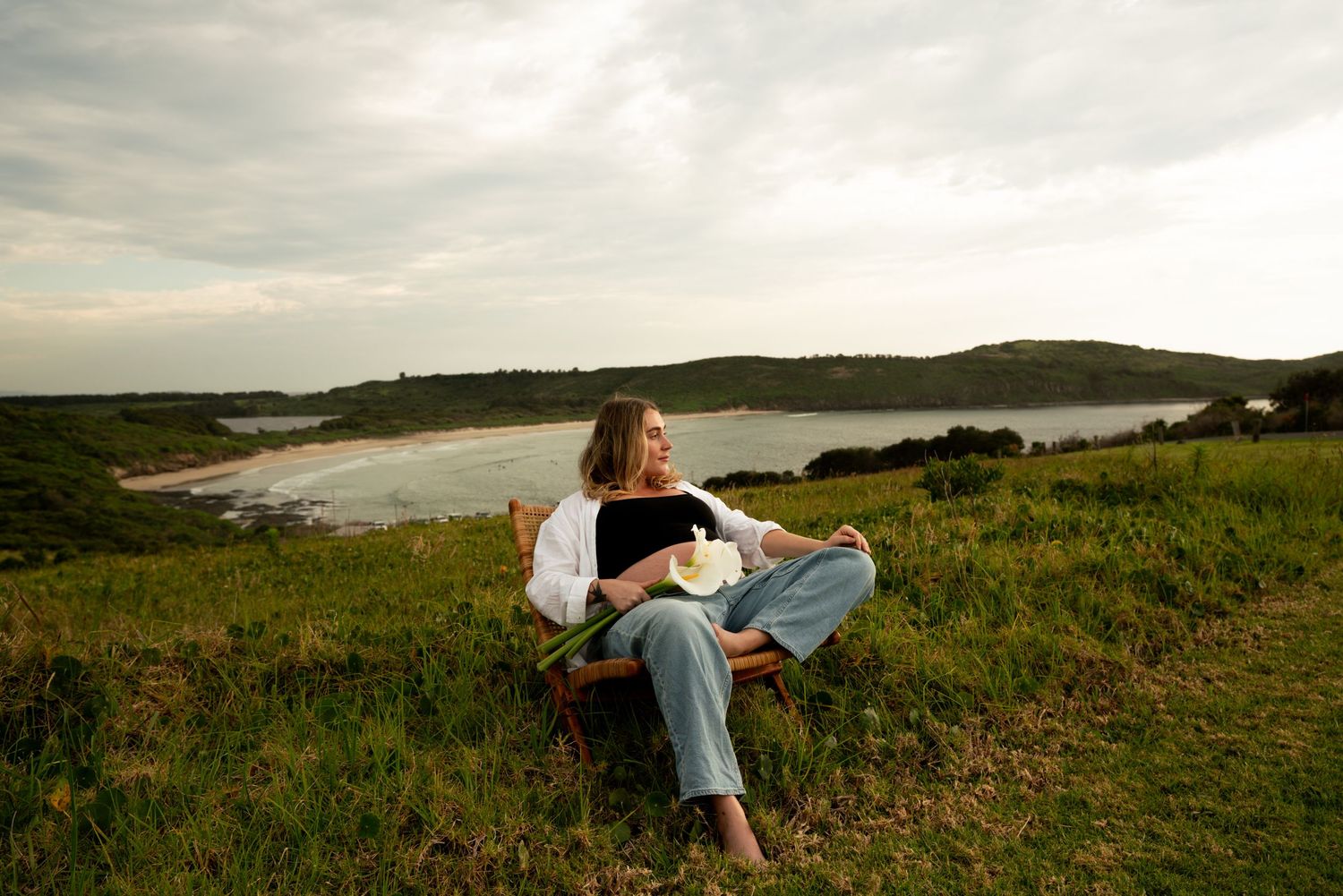 Maternity photoshoot on coastal hillside with ocean views.