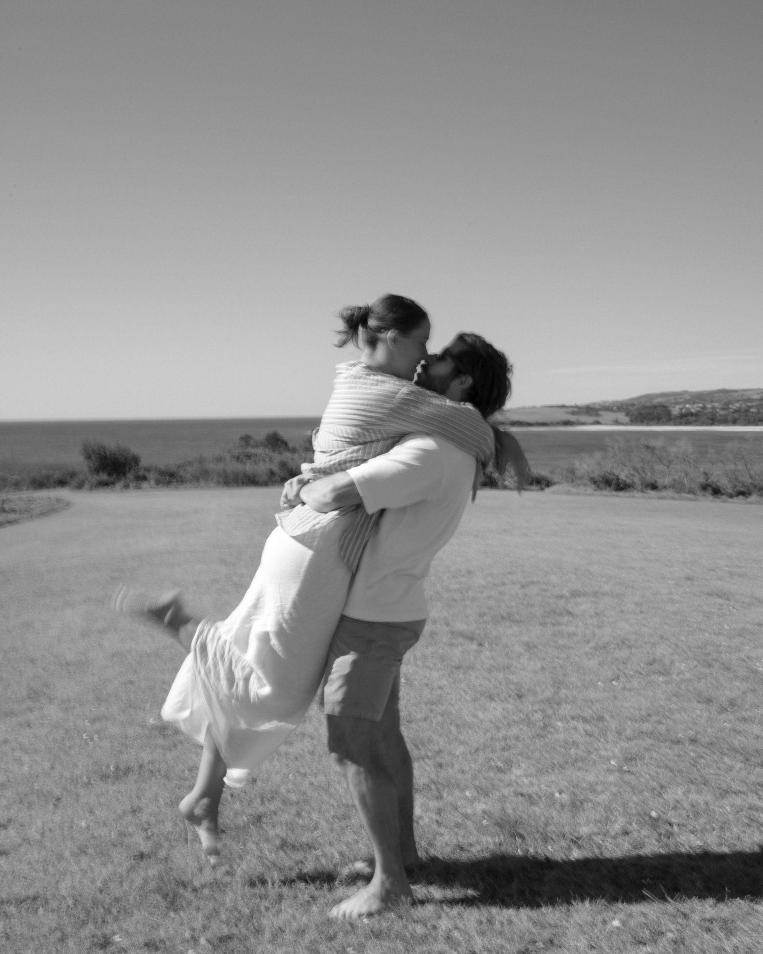 A romantic sequence of black and white photos showing a couple dancing and embracing in an open field.