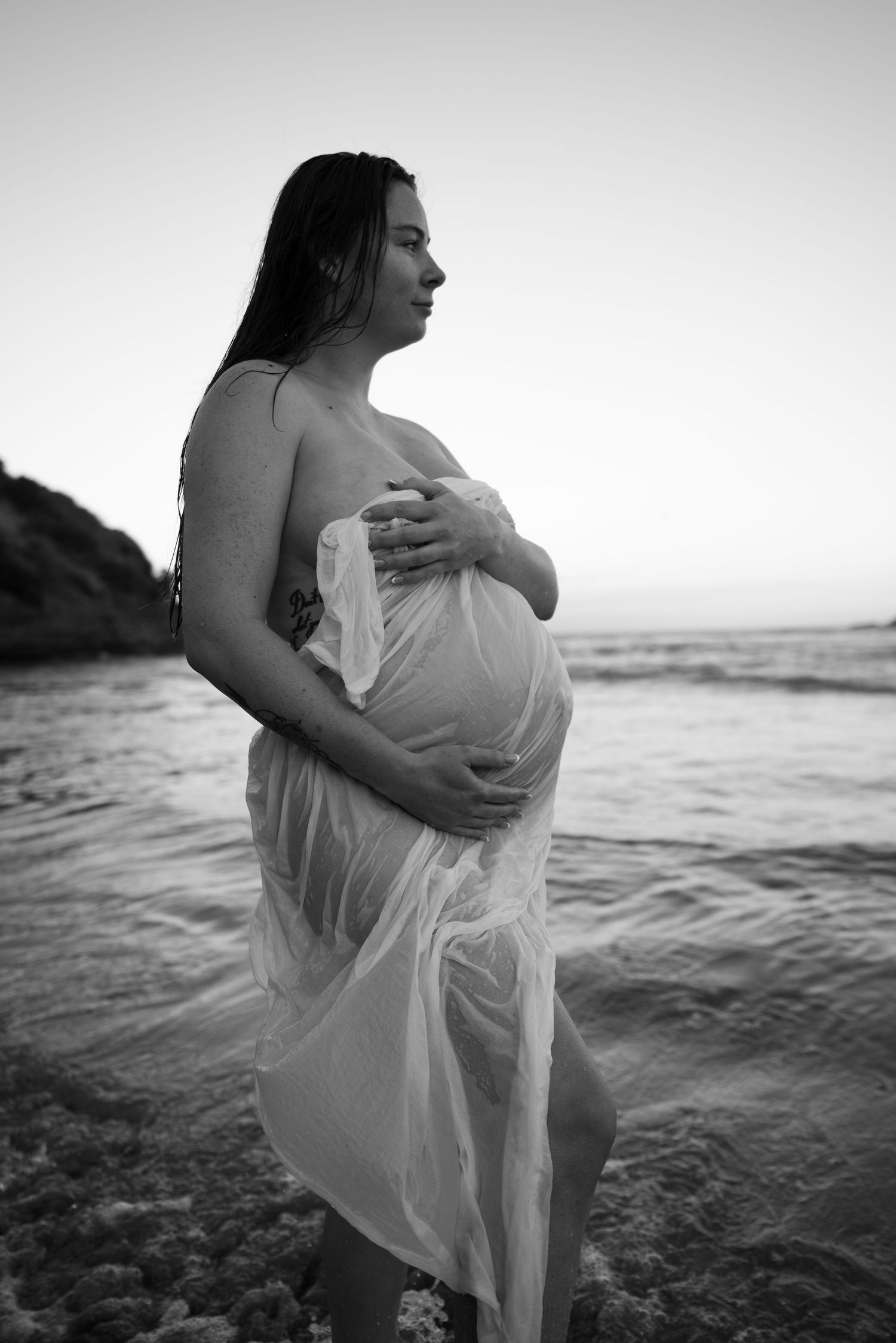 Black and white beach maternity photos with flowing white fabric.