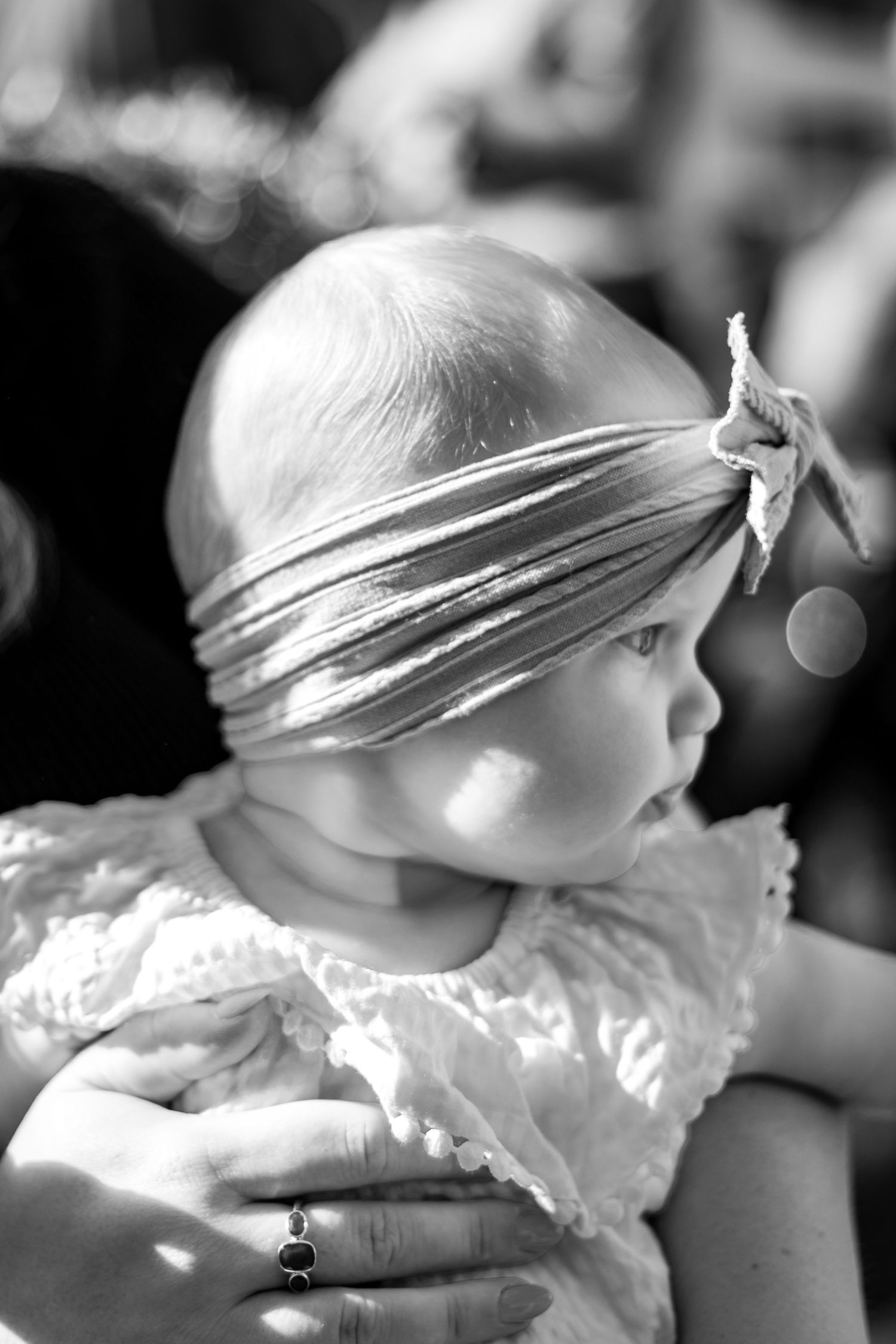 Black and white profile shot showing someone wearing a delicate headband in sunlight.