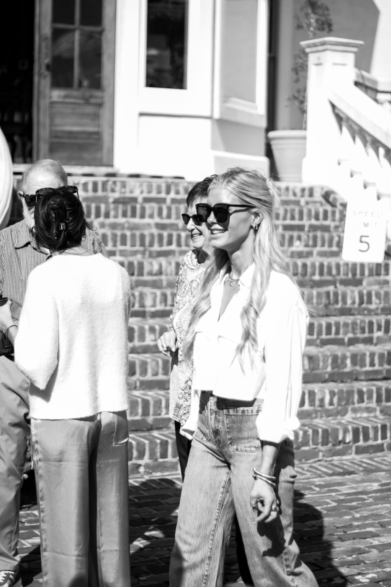 People standing on brick steps in casual attire during an outdoor event.