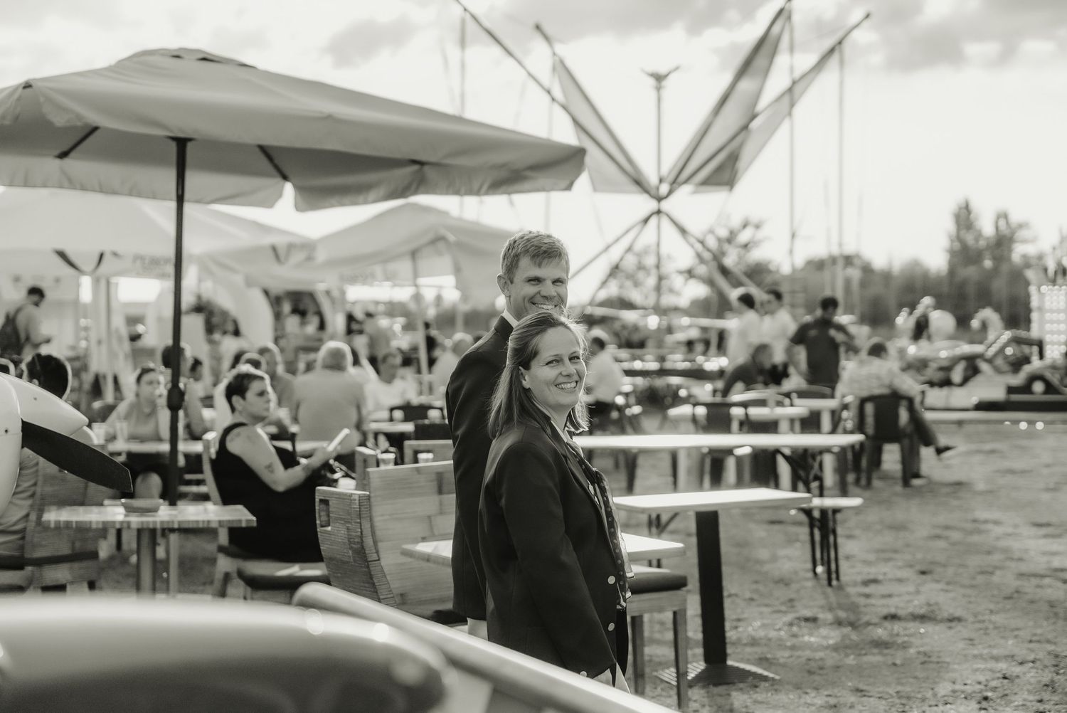 A series of black and white photographs showing people at an outdoor market with tents and vendor stalls.