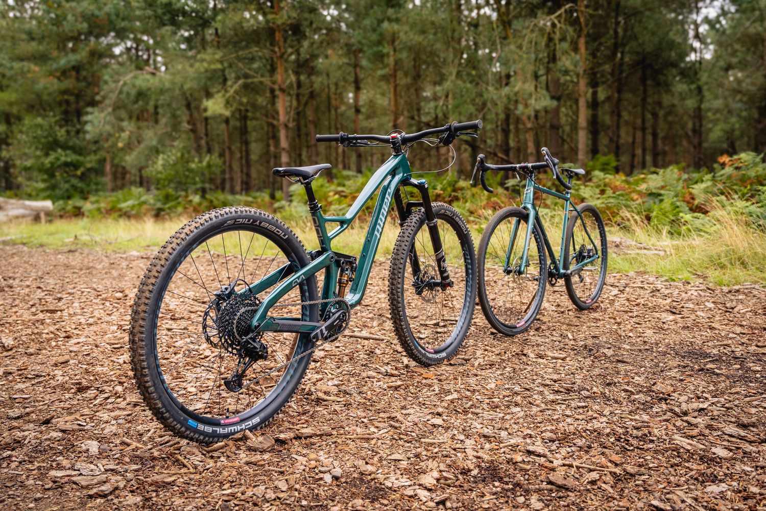 A row of turquoise mountain bikes lined up on a forest trail showing different angles and perspectives.
