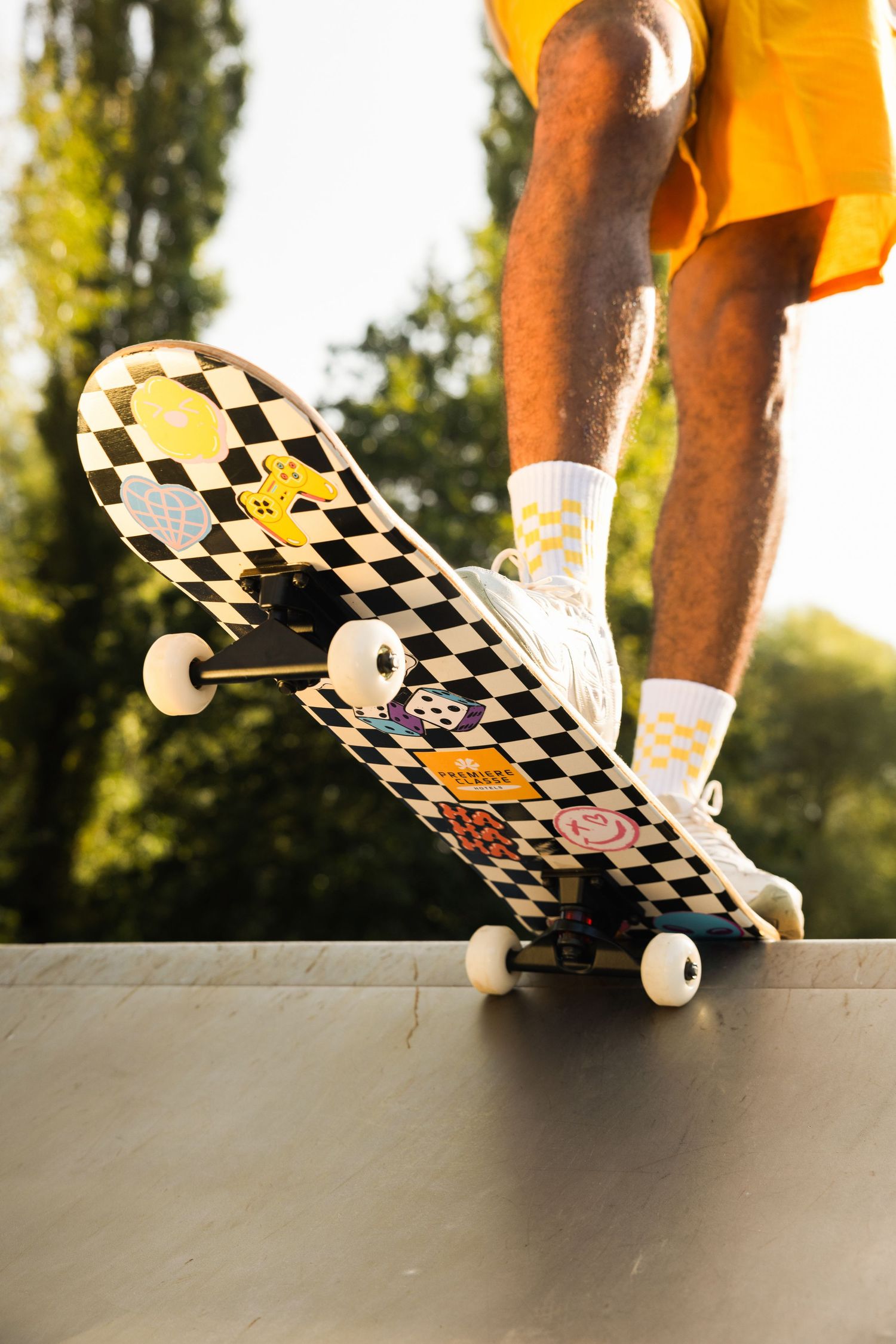 A sequence of skateboard tricks showing a board flipping and rotating against a sunlit outdoor background.