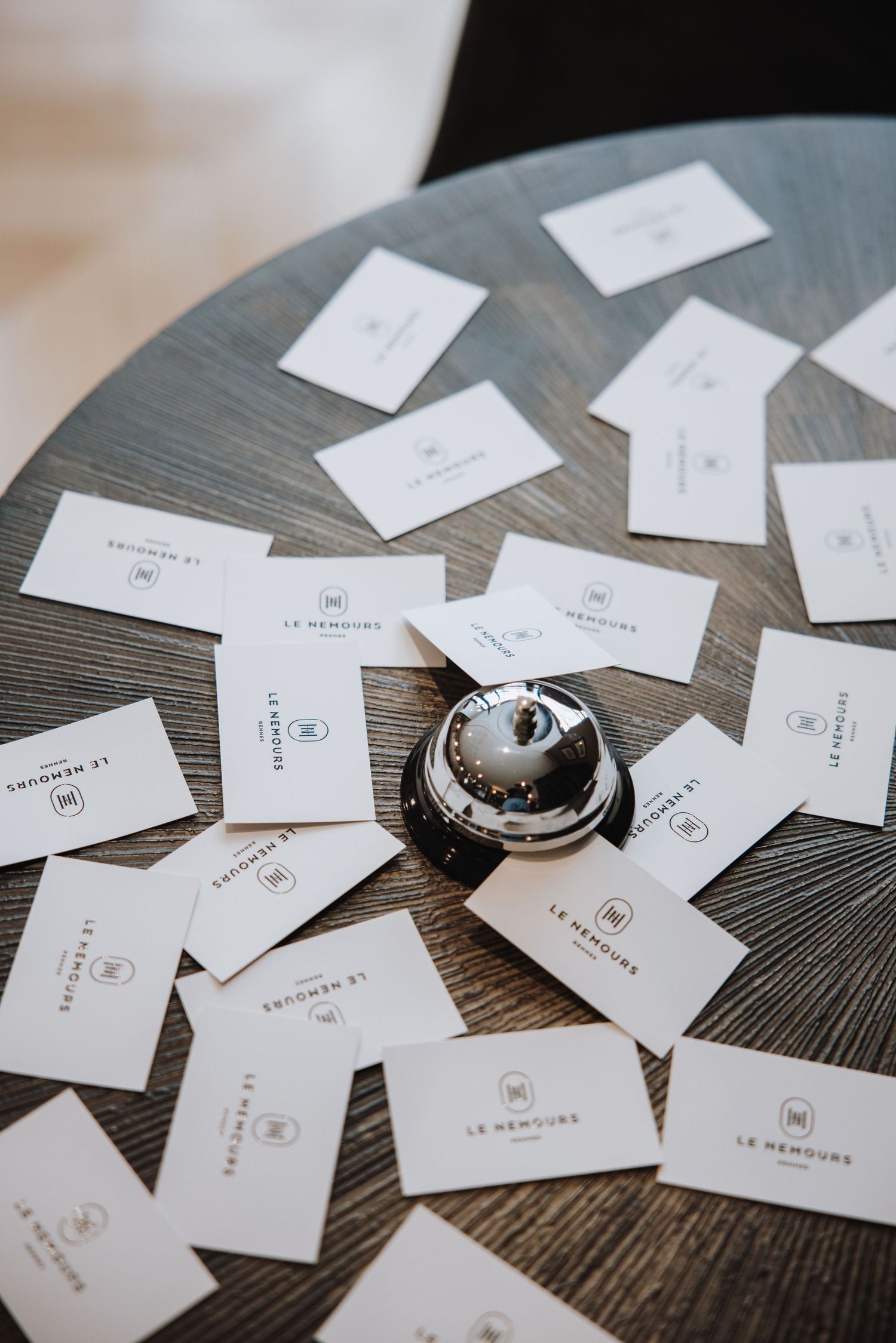 Business cards scattered across a dark wooden surface with minimalist branding and design elements.