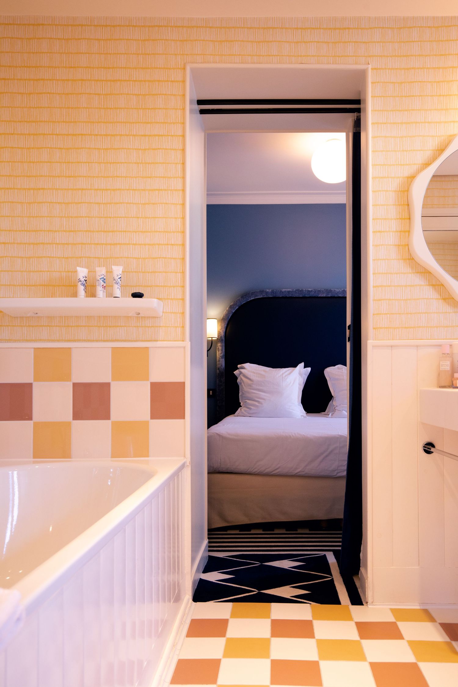 A series of minimalist interior photos showing white walls and orange checkerboard tile patterns leading to a bedroom doorway.