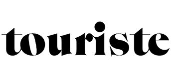 Black typographic logo design spelling out 'touriste' in a stylized lowercase font with a dot accent above the i.