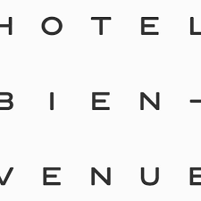 A modern hotel exterior sign with illuminated letters spelling out HOTEL against a dark background.