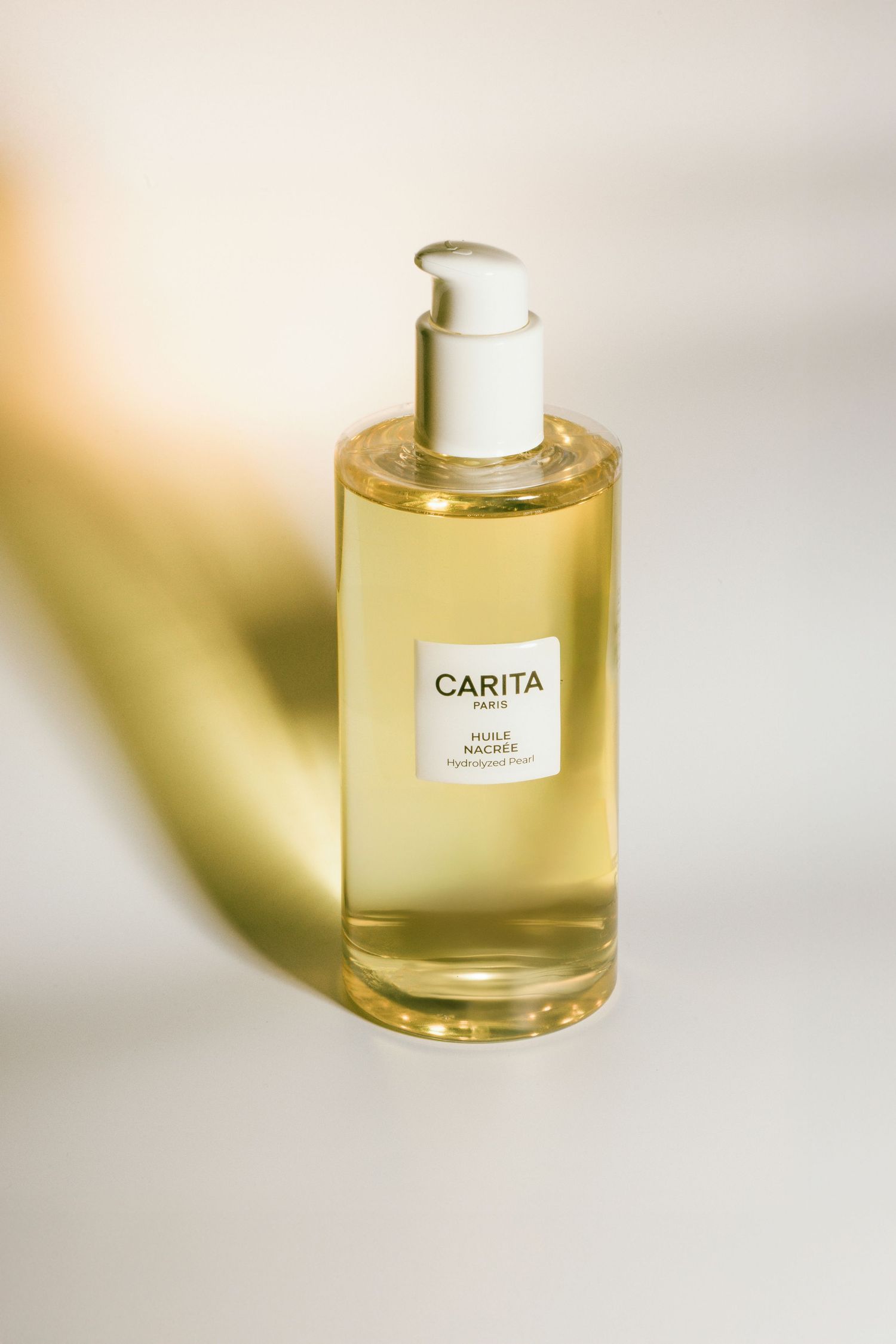 Luxury perfume bottle collection of Carita Paris fragrances in golden hues displayed against a soft white background.