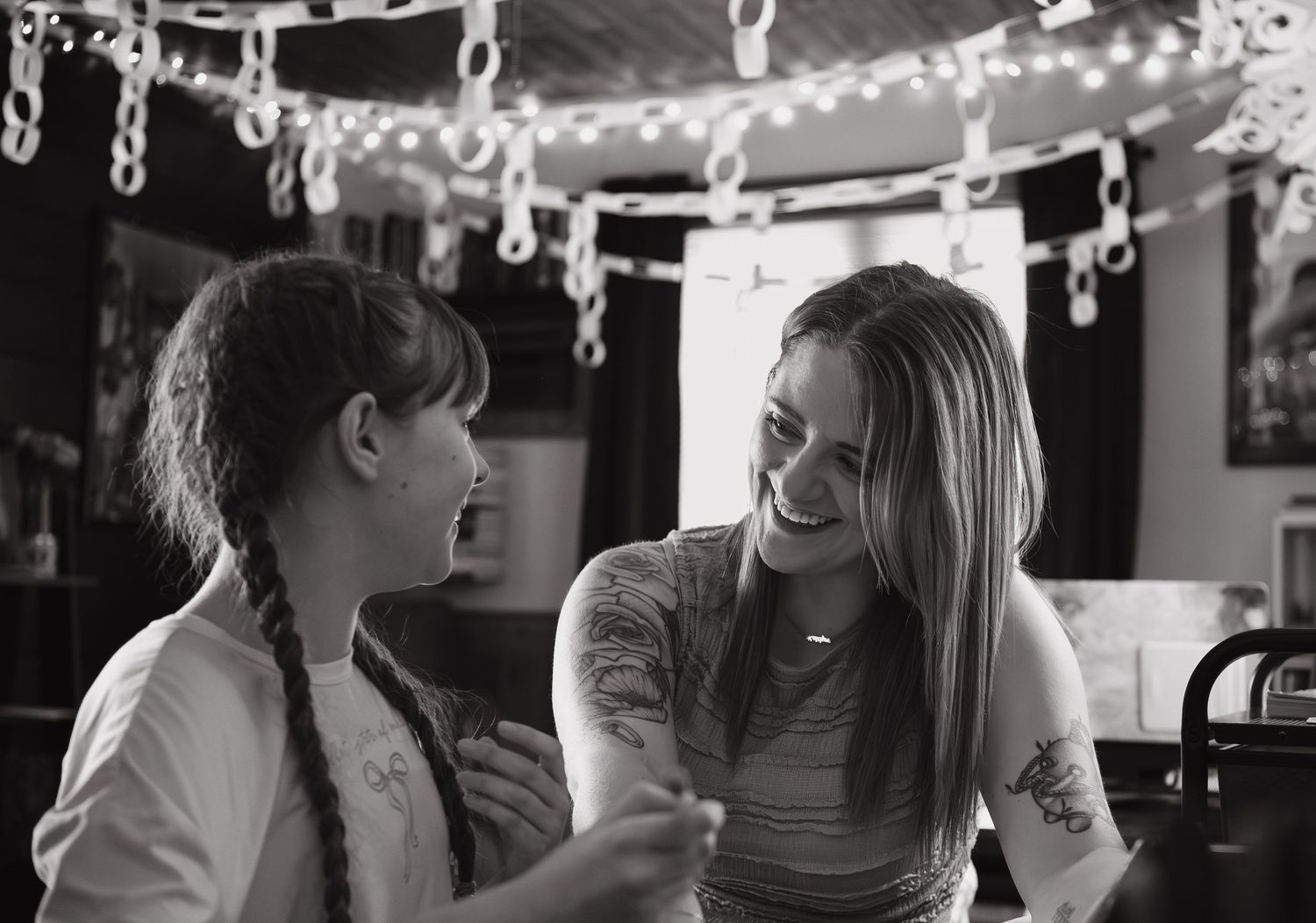 Black and white photo sequence showing candid laughter and joy at an indoor gathering.