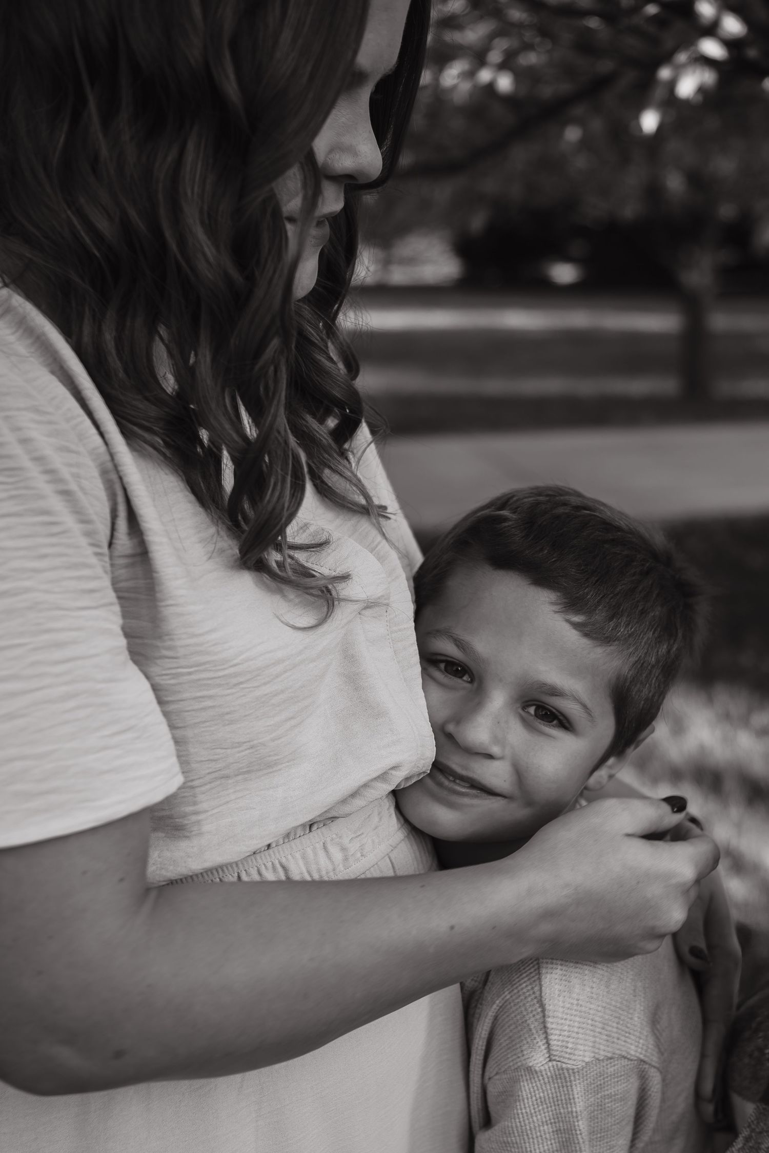 Black and white portrait showing a tender moment between parent and child.