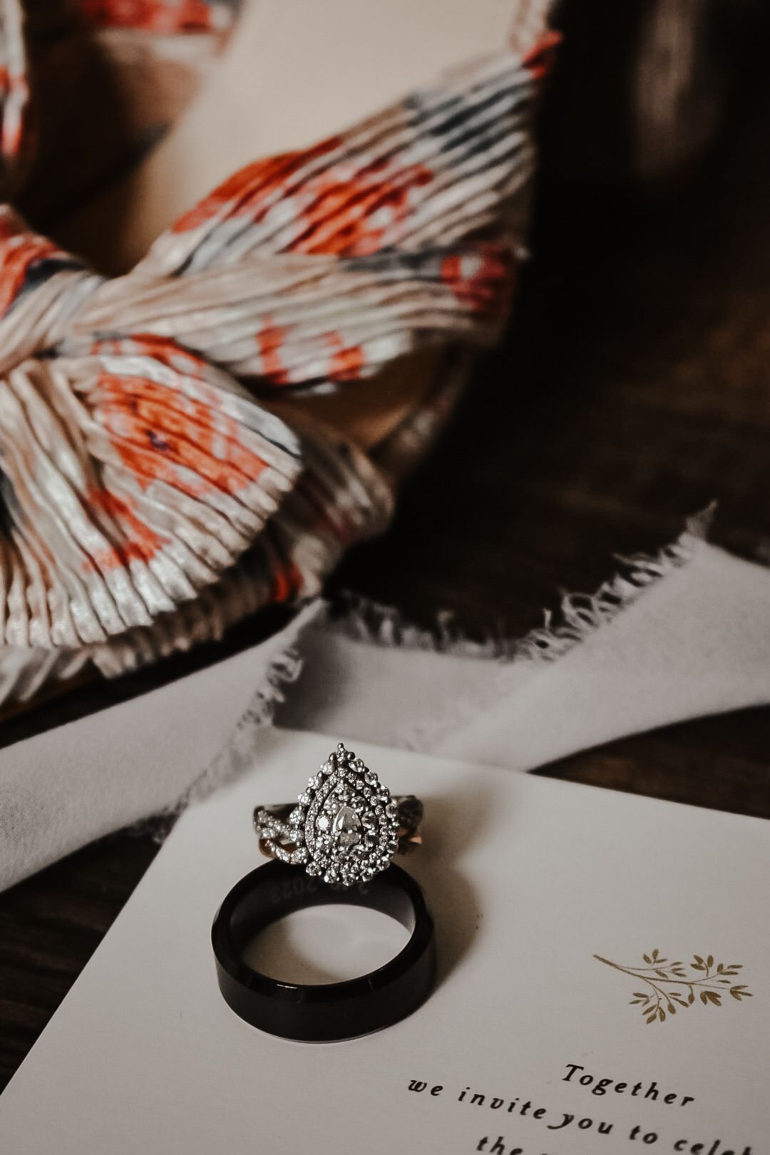 Artistic detail shot of wedding stationery and decorative elements in moody lighting.