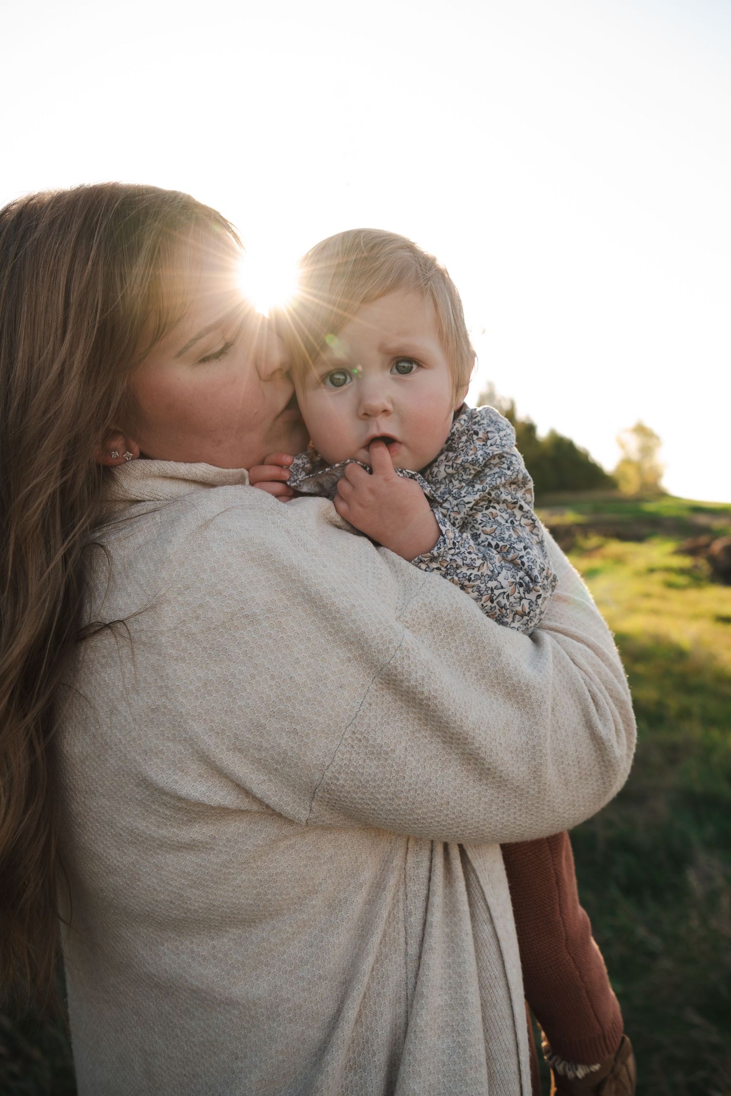 Parent and child sharing a tender moment in golden sunlight.