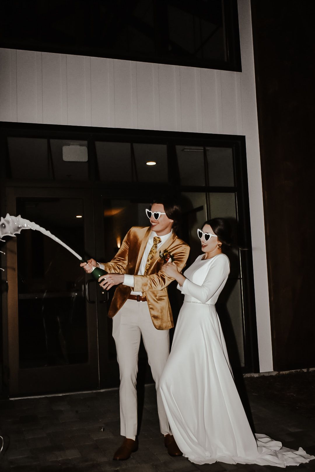 Night wedding photography with couple in formal attire creating dramatic lighting effects.