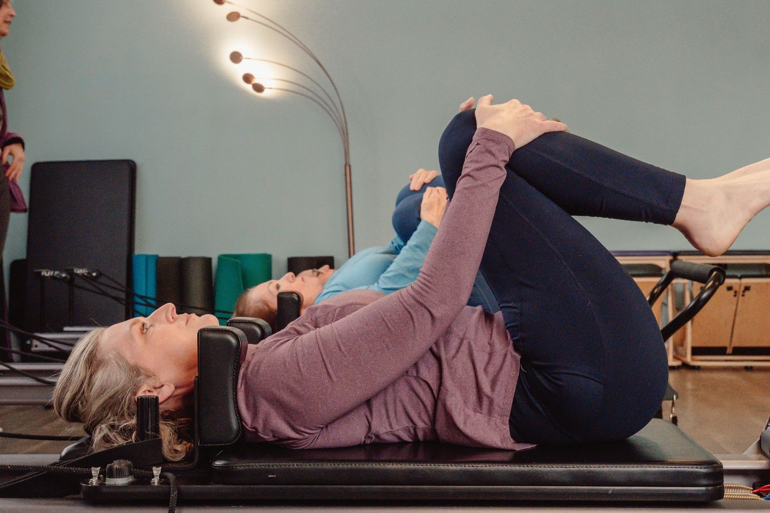 Clients participating in a reformer Pilates session photographed for a boutique wellness studio.