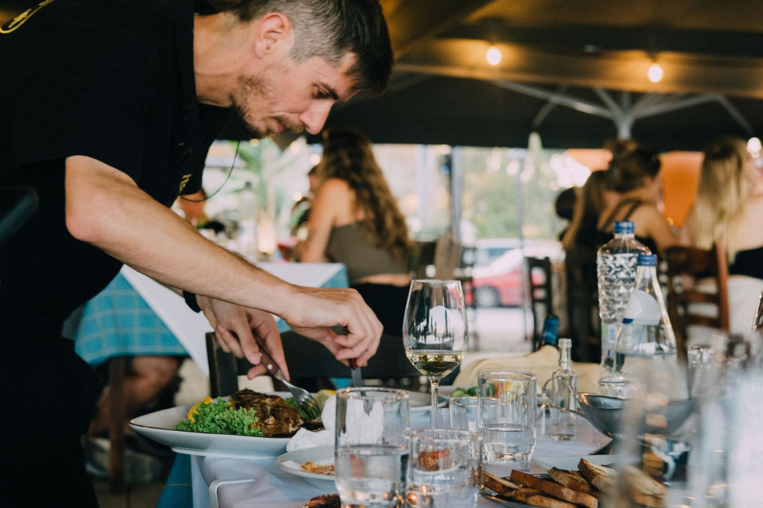 Chef preparing fresh ingredients at an outdoor dining event.