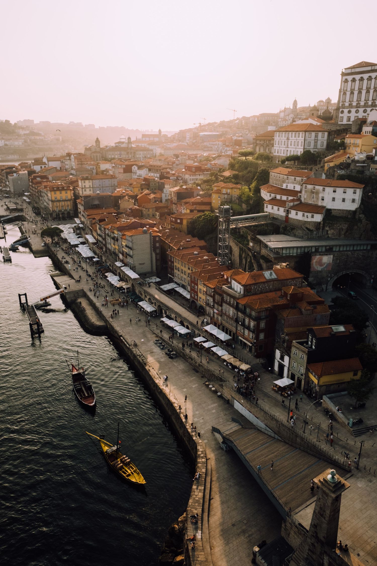 Aerial view of Porto's riverside with traditional buildings and boats on the Douro River.