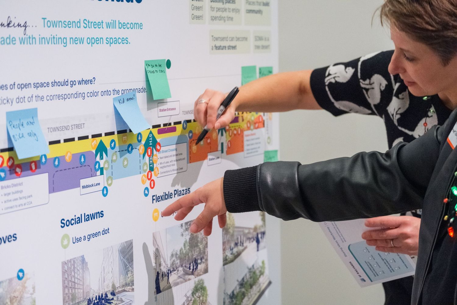 Team collaborating at a whiteboard covered in colorful sticky notes during a planning session.