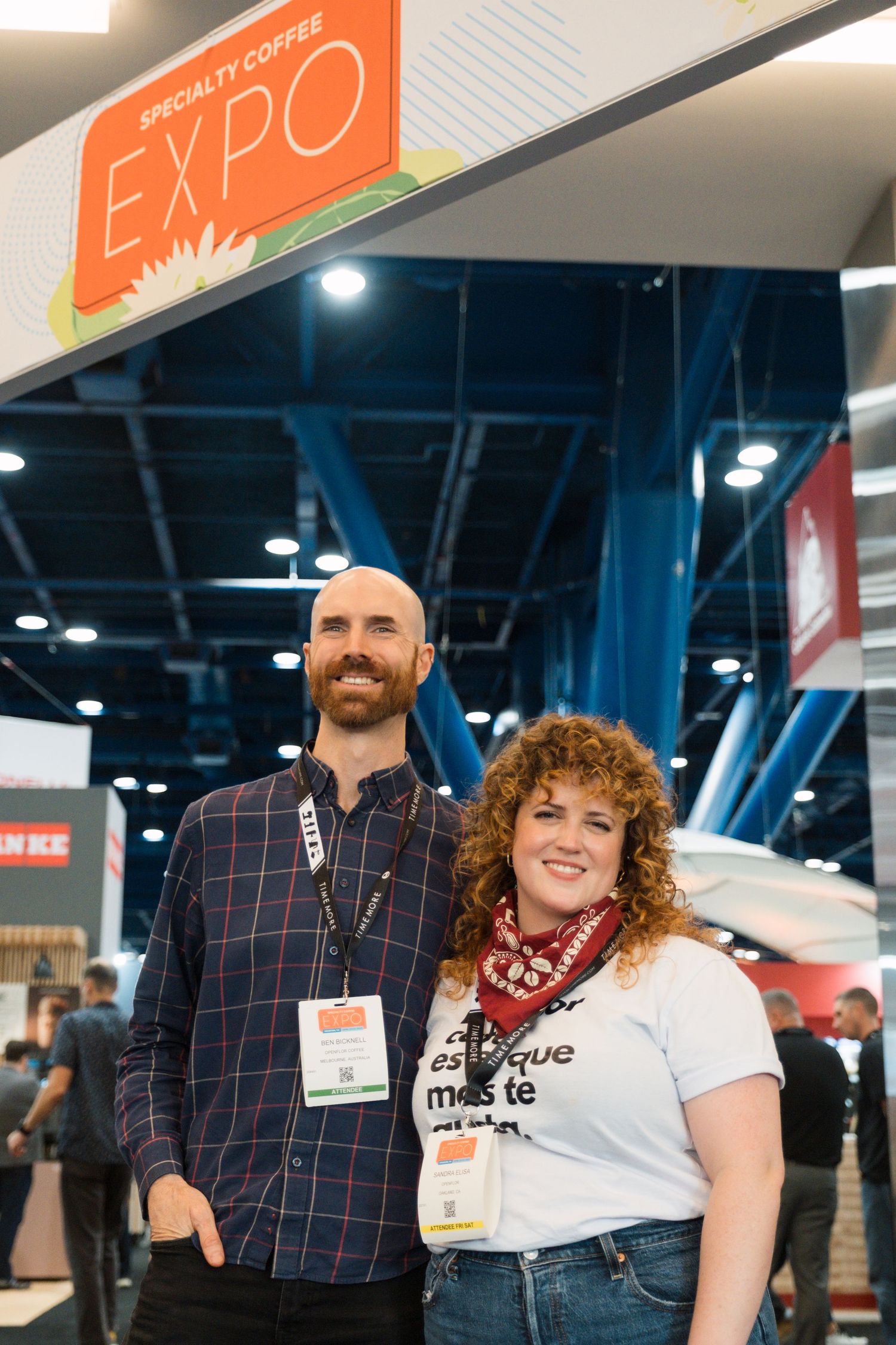 Attendees posing together under an orange EXPO sign at a specialty coffee trade show event.