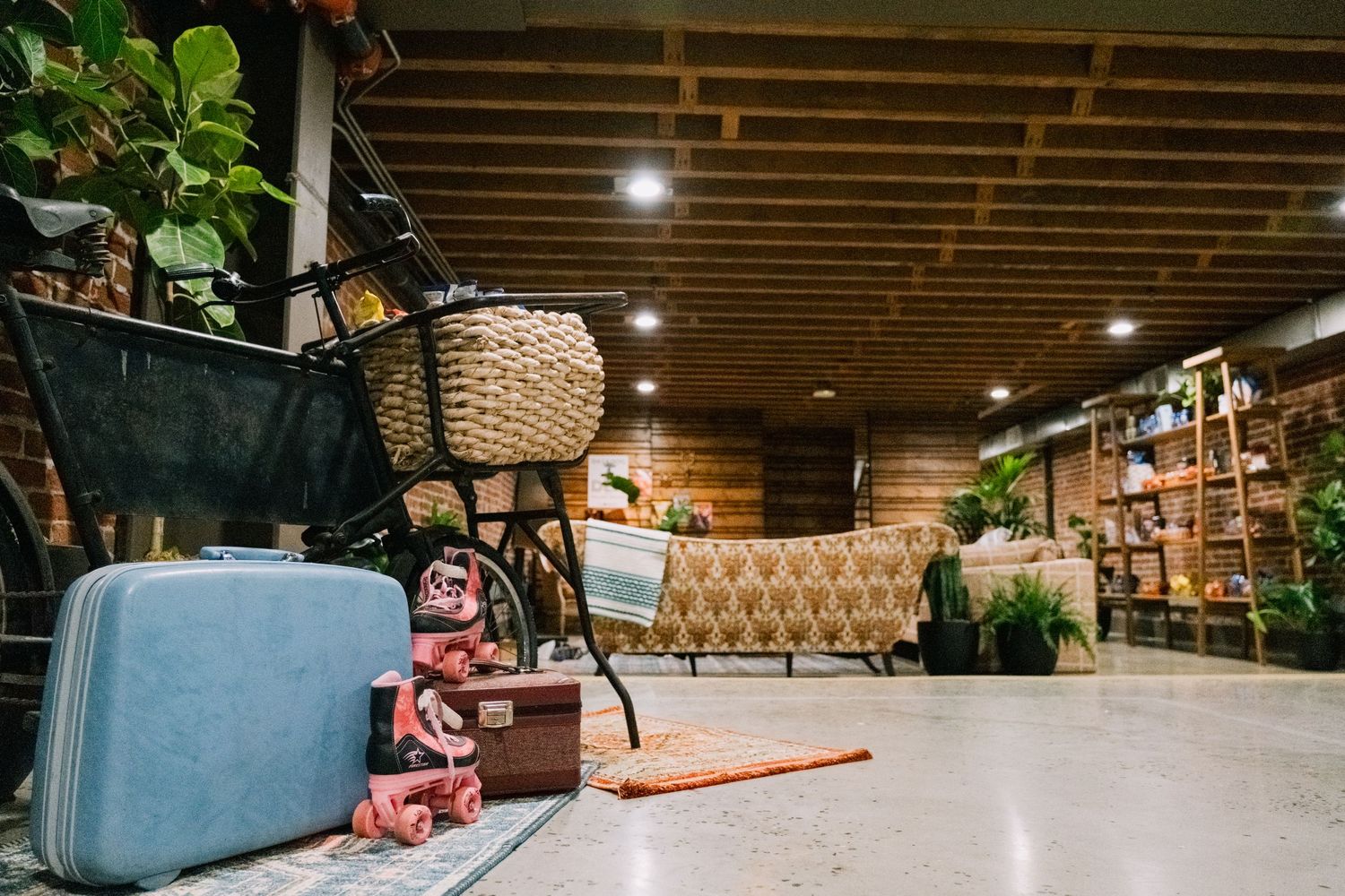 Vintage decor in retail space with blue suitcase and woven baskets.