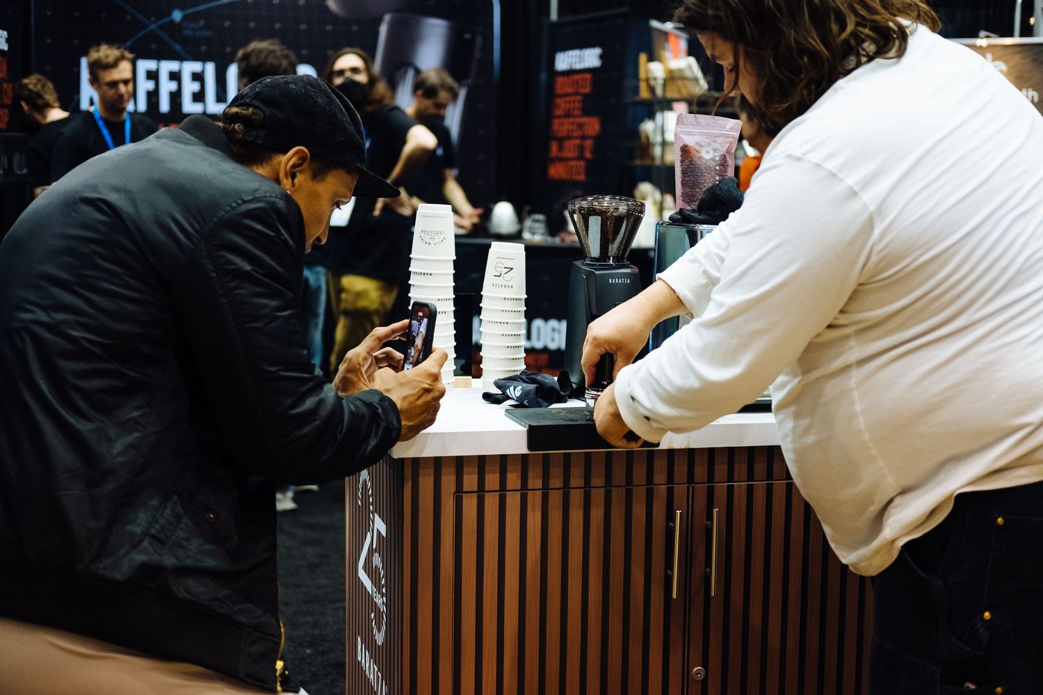 Staff members working behind a wooden bar counter at a venue.