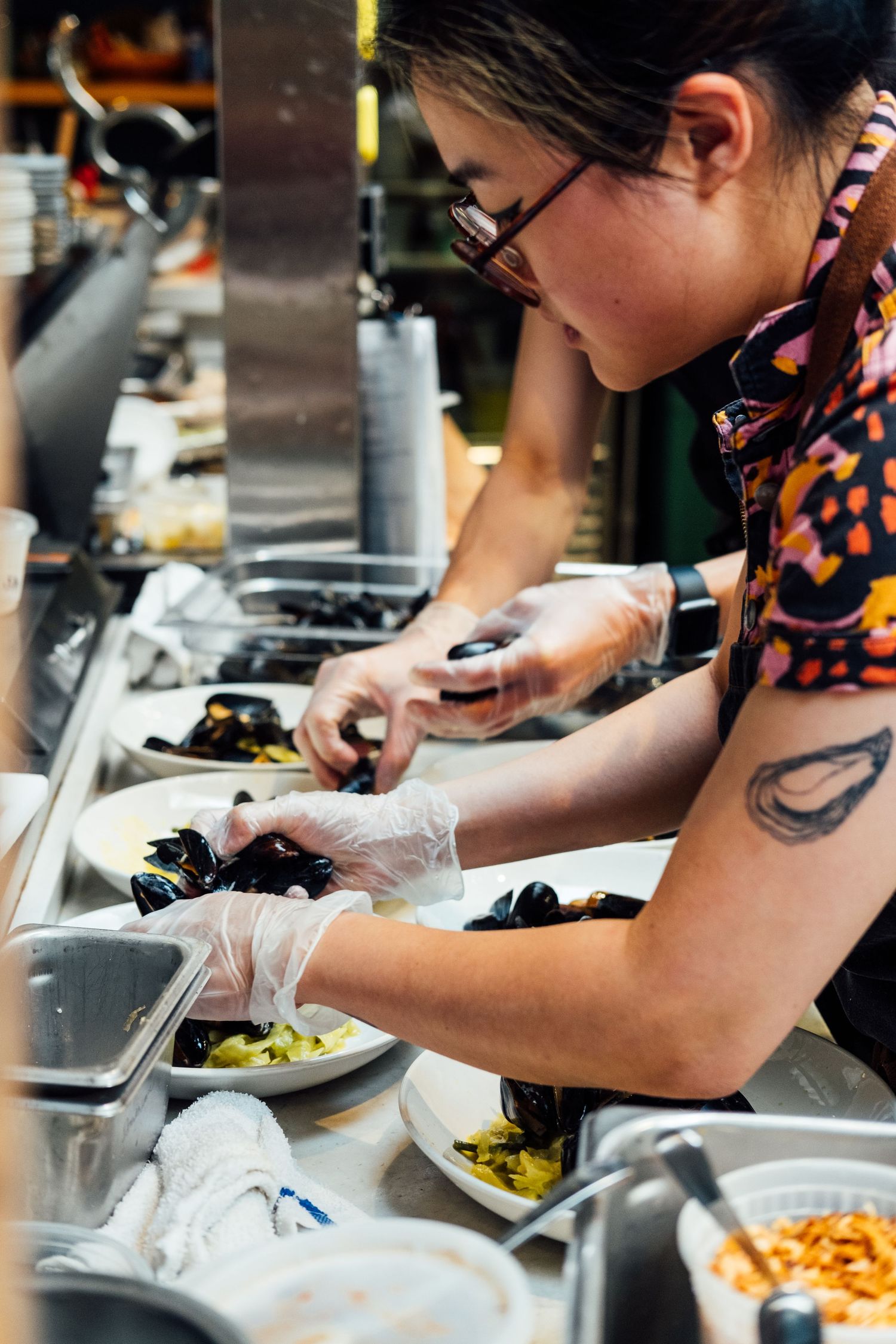 Professional cook preparing ingredients in a busy restaurant kitchen.