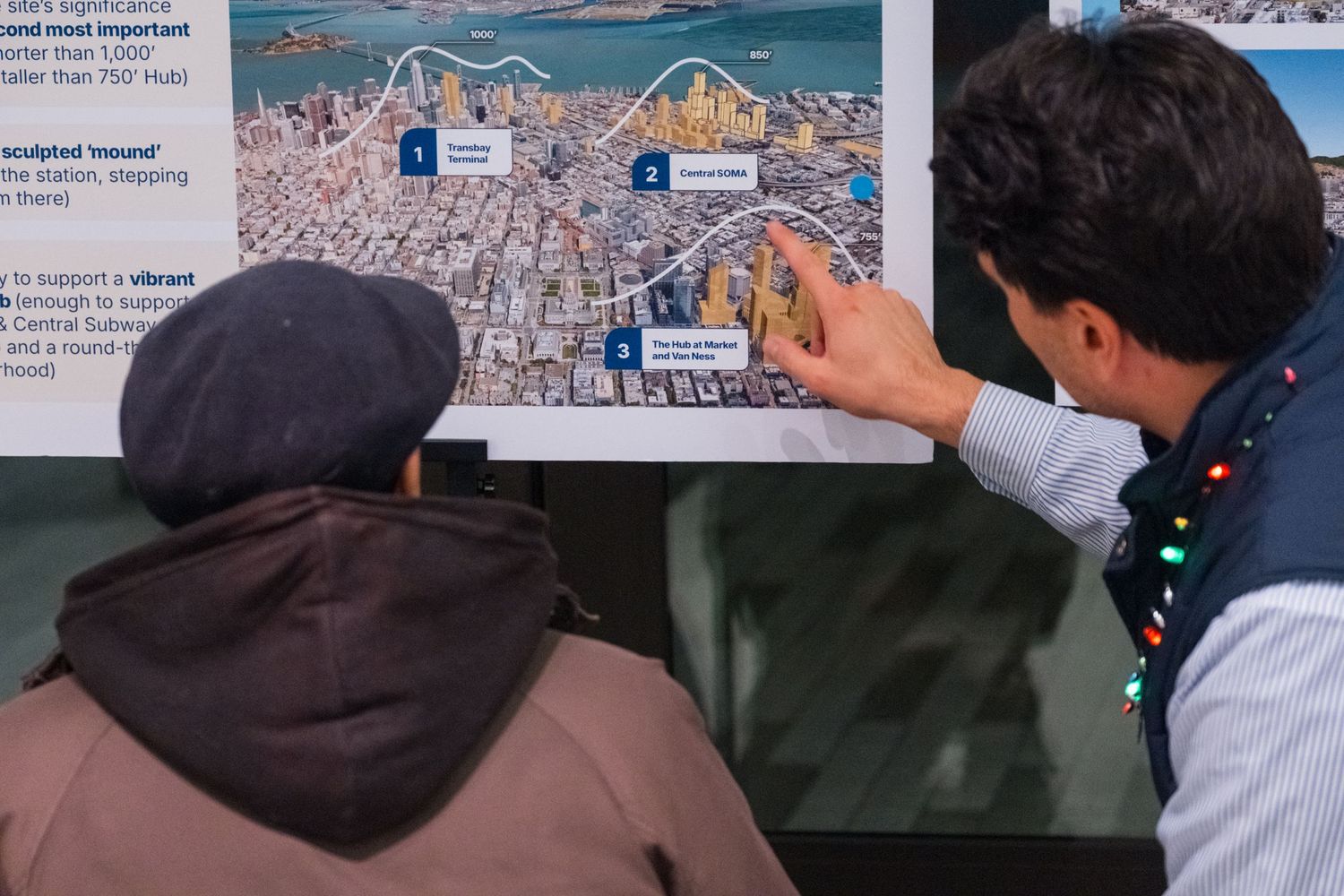 Group viewing presentation materials and maps displayed on a wall during a workshop.