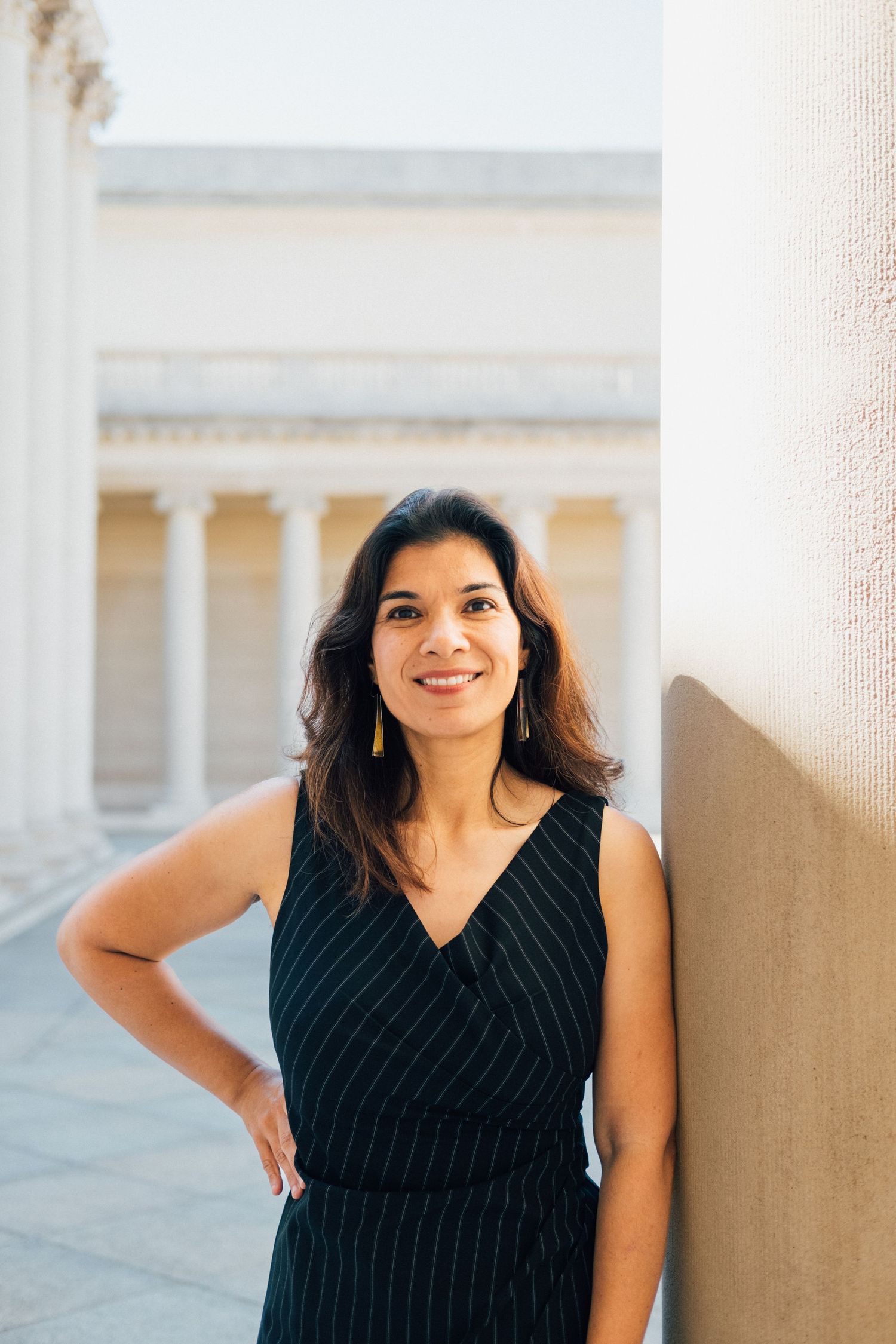 A professional portrait series taken against a light architectural backdrop with columns and clean lines.
