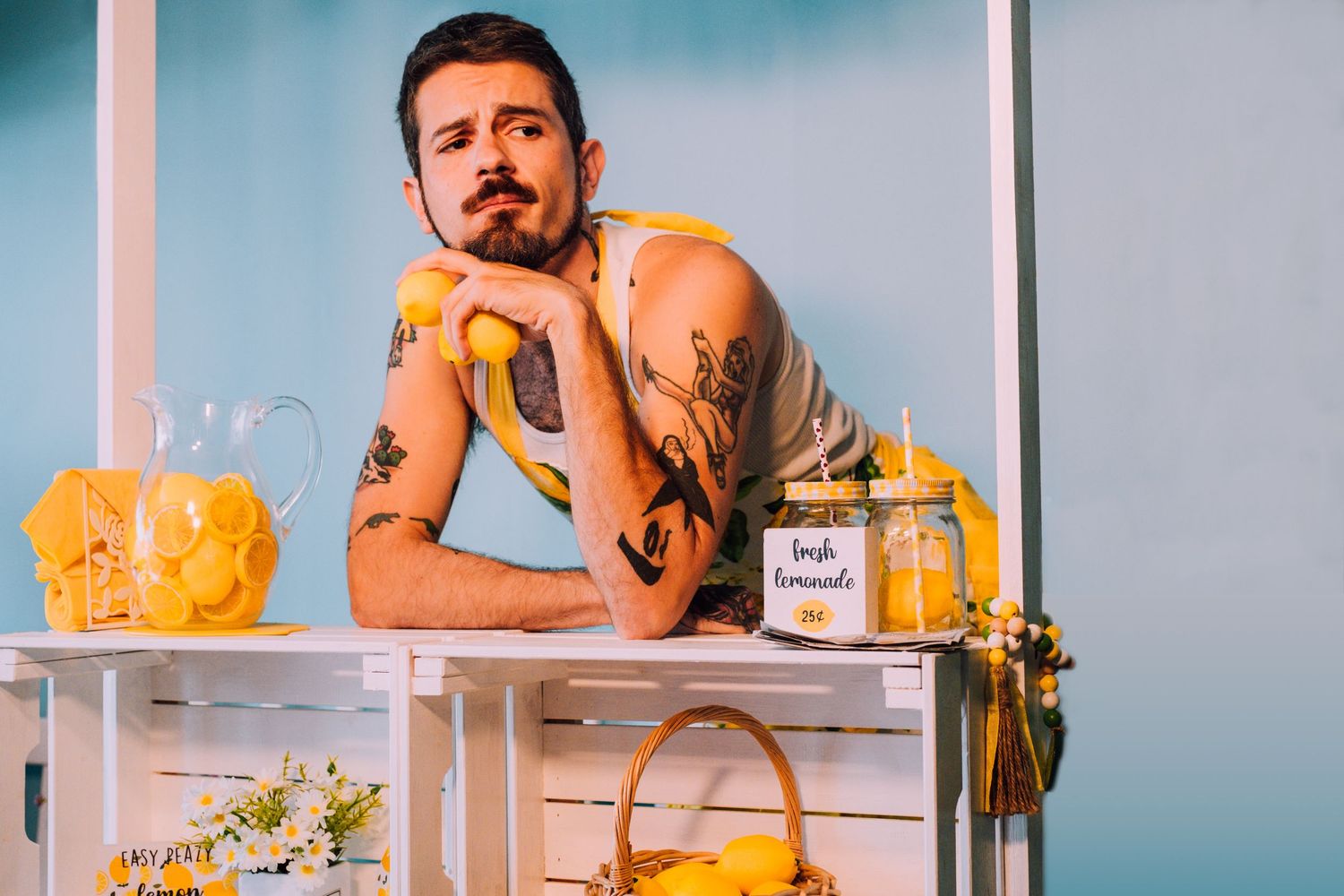 Creative entrepreneur lifestyle shot holding lemons at a lemonade stand. Pose conveys thought and empathy. San Francisco brand photographer