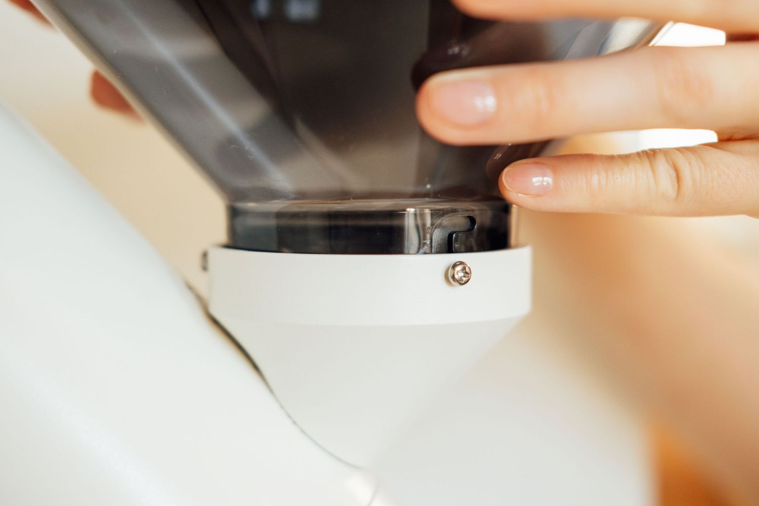 Close-up of coffee grinder being adjusted for optimal grind size.