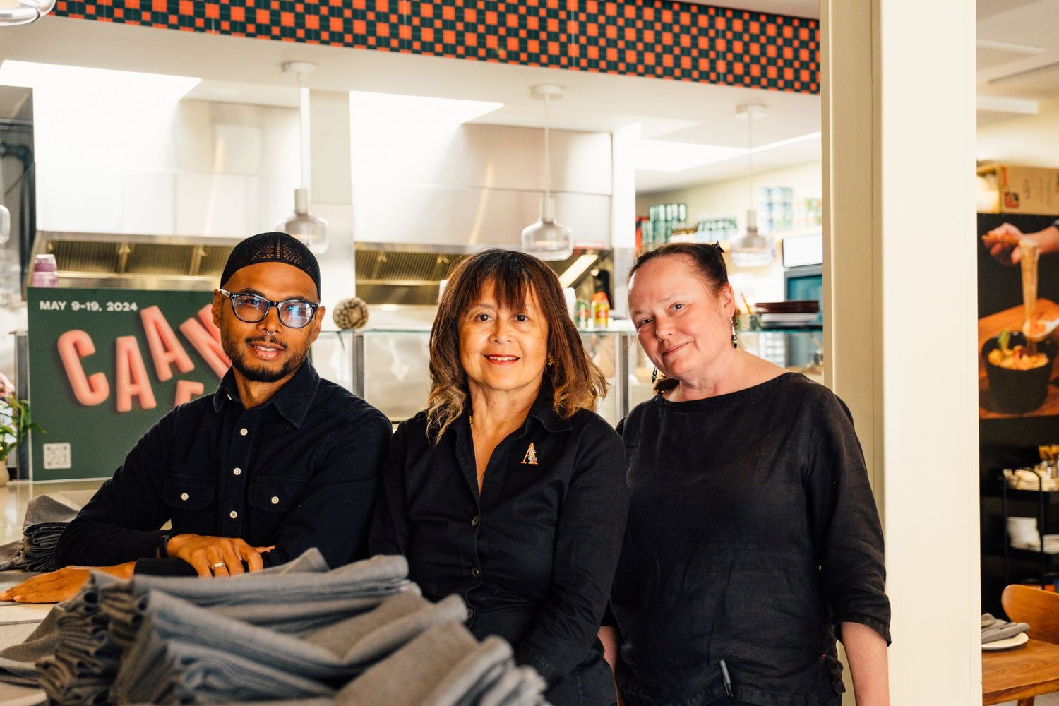 Retail staff members standing together in store near clothing display.