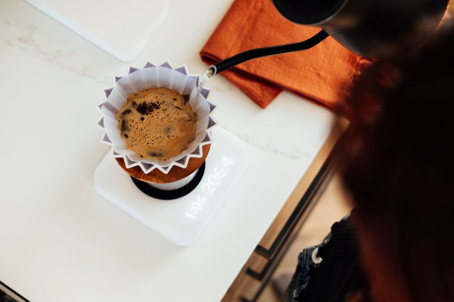 Overhead view of a coffee filter basket containing freshly ground coffee beans.