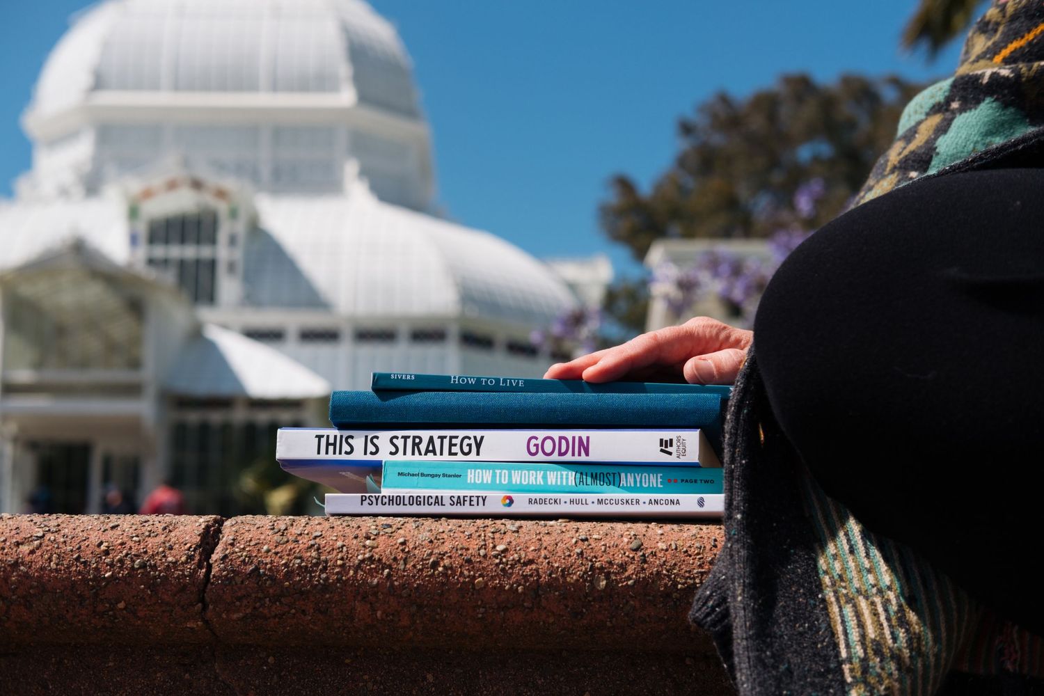 Pile of business books, illustrating a Bay Area coach's focus in sharing resources with her clients. From a personal branding photoshoot.