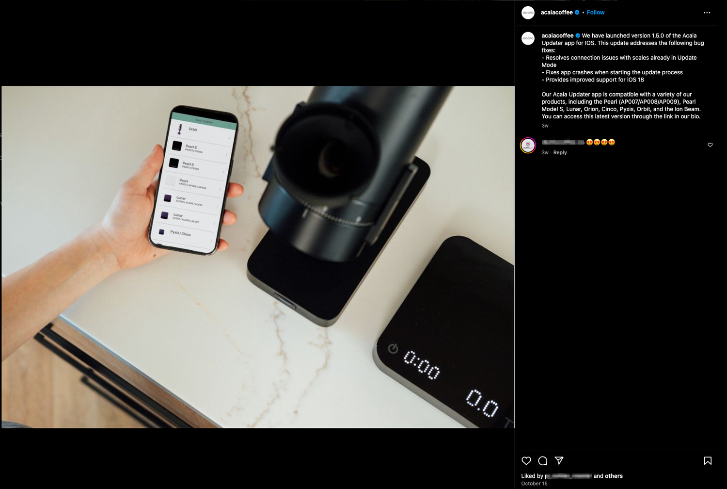 Hand holding smartphone next to coffee brewing equipment on white surface.