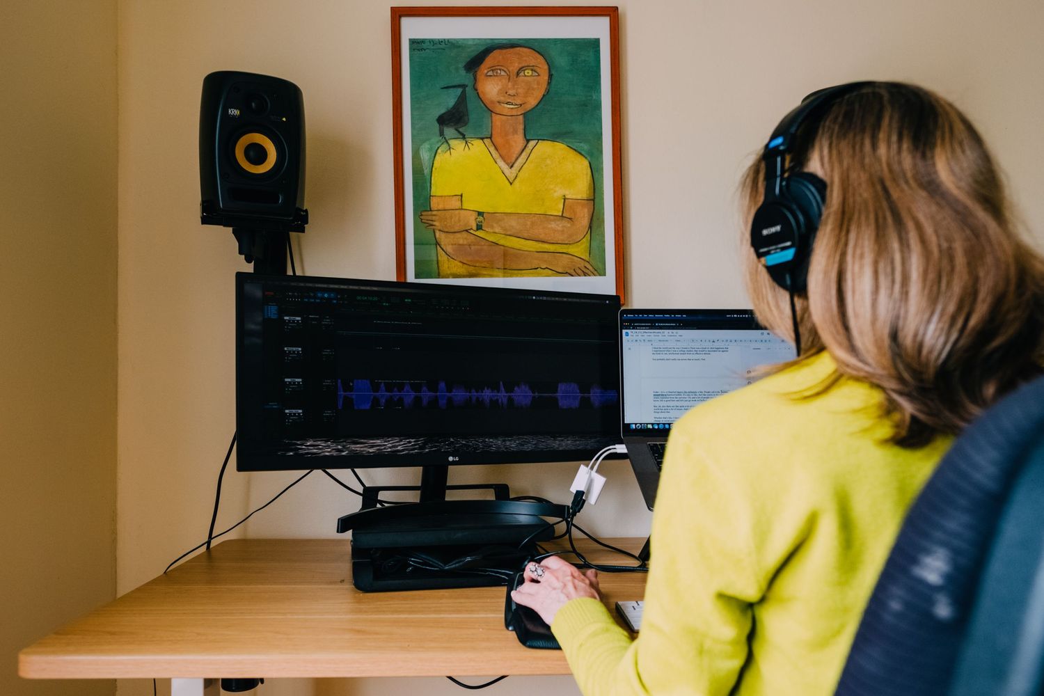 Home recording studio setup with monitor, speaker, and artwork.