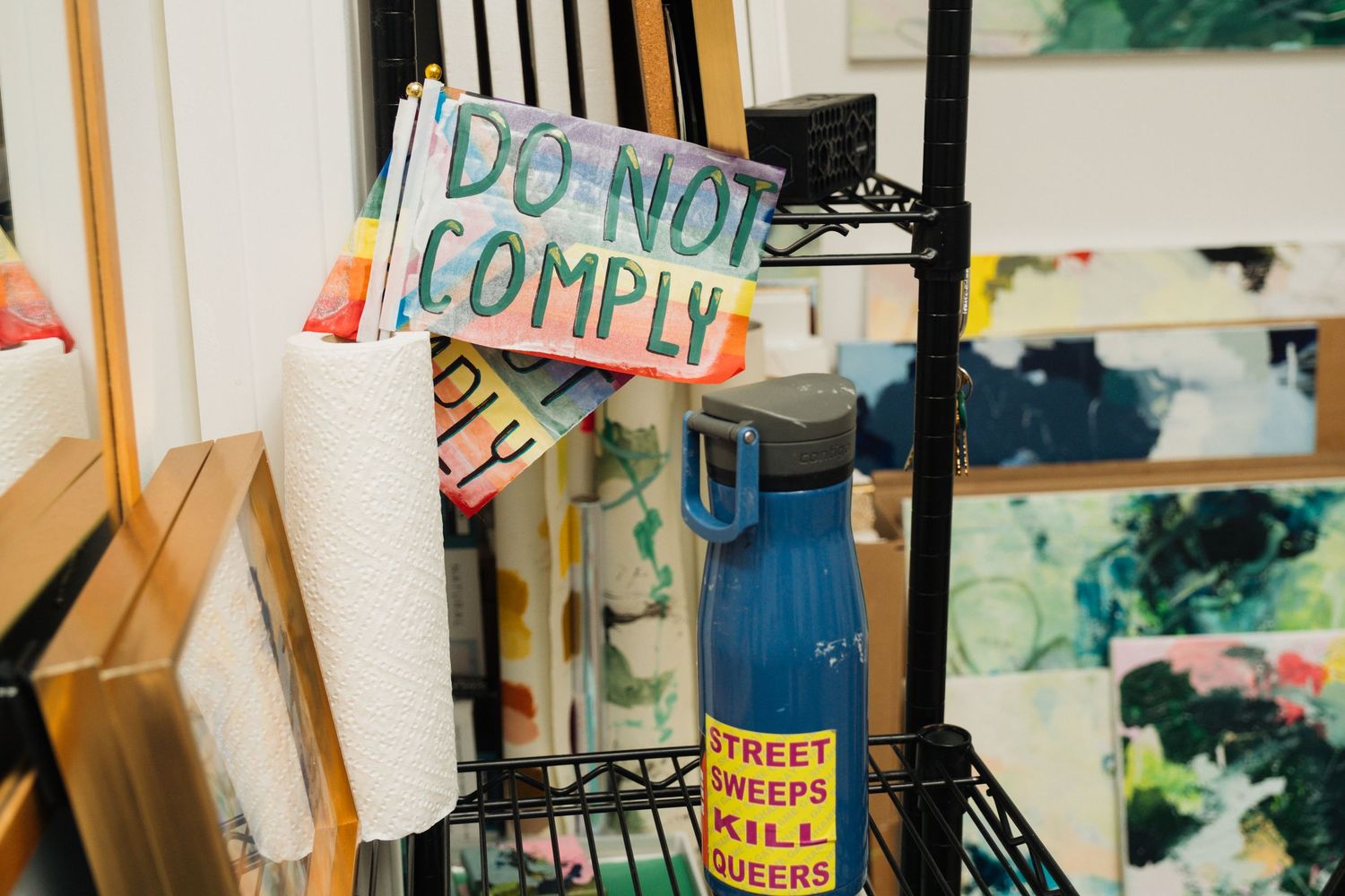 Colorful protest sign in an art studio. Example of personal brand custom stock photo for an artist. Photoshoot by Jenn Chen Media.