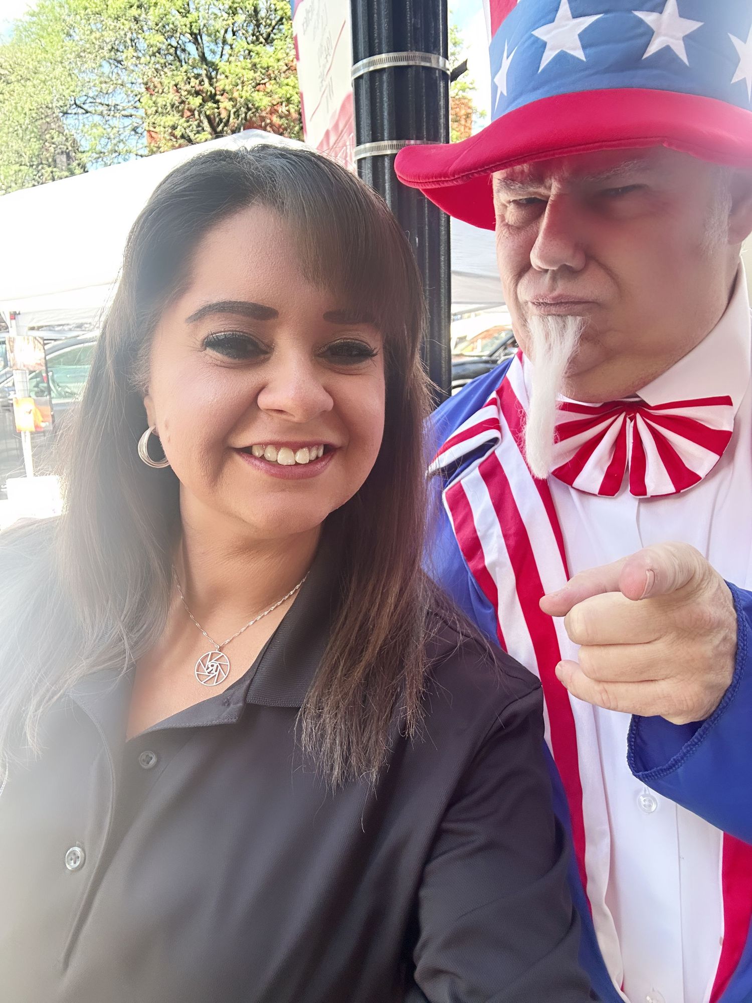 Two people wearing patriotic American-themed baseball caps and clothing smile and pose together.