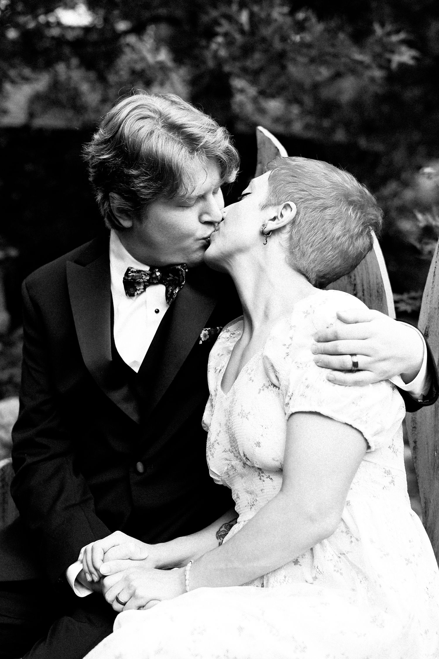 A romantic black and white wedding photo series showing a couple sharing intimate kisses in formal attire.