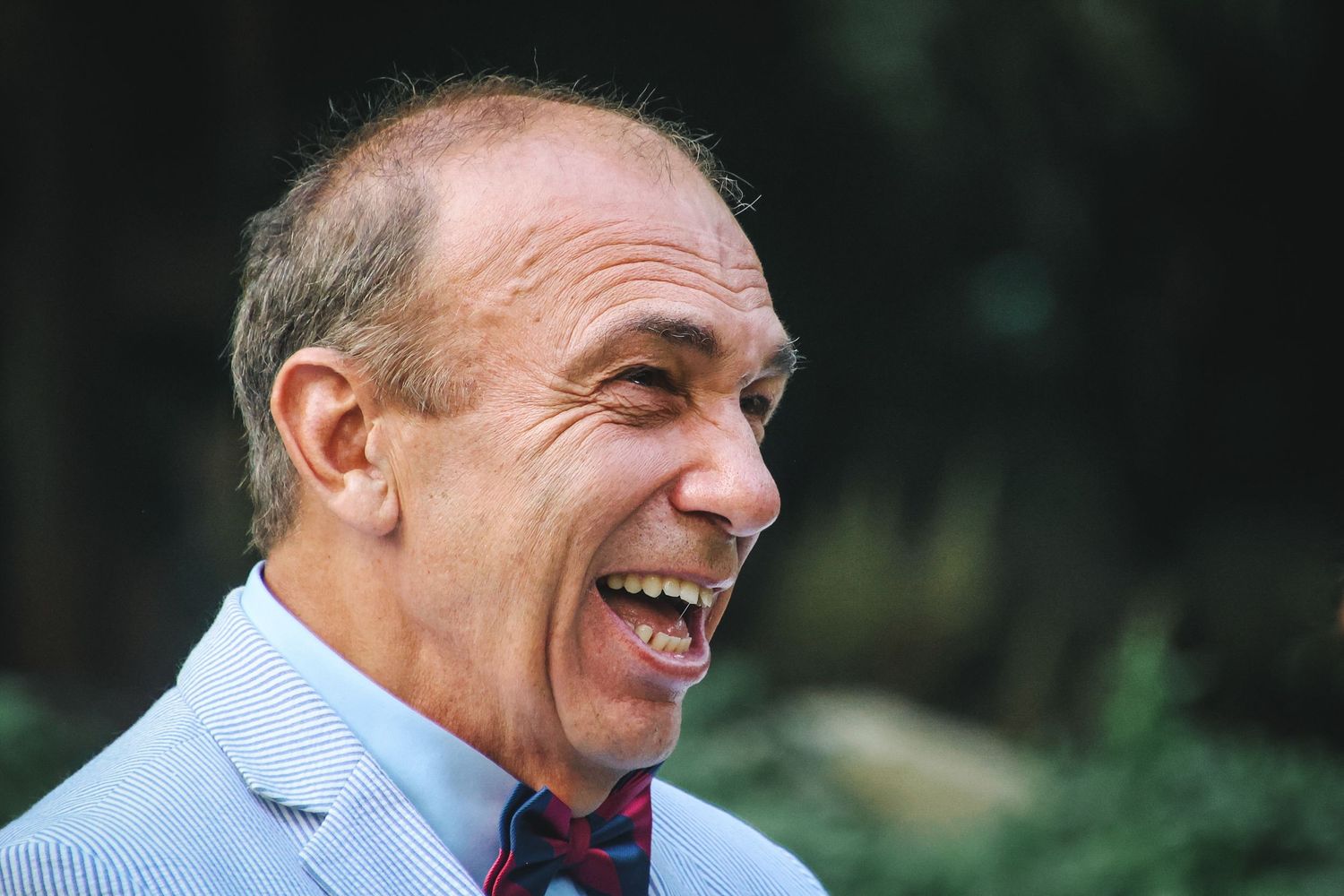 A sequence of five candid photos showing someone in a light blue shirt laughing and smiling expressively.