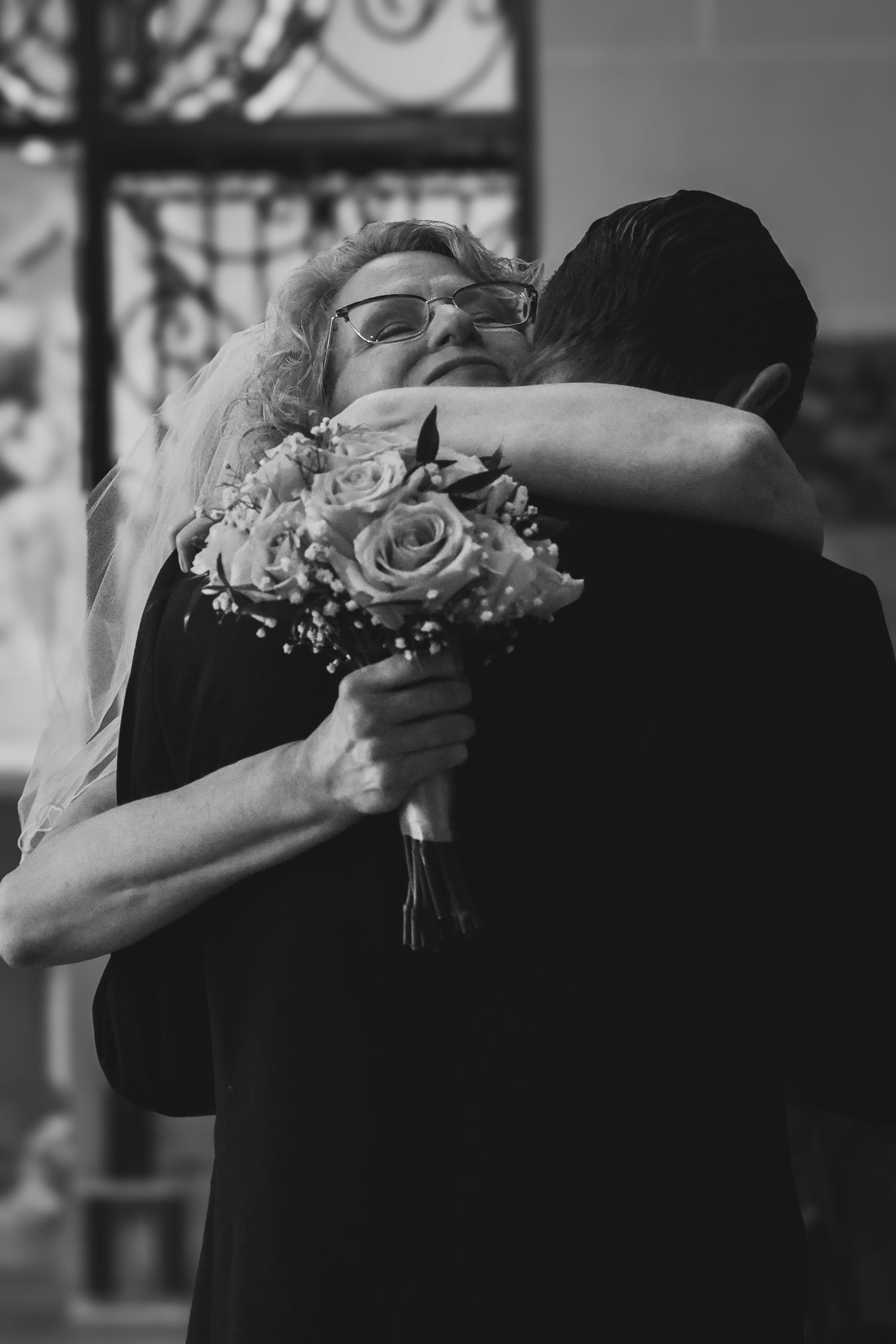 A tender black and white wedding dance moment captured as the couple embraces on the dance floor.