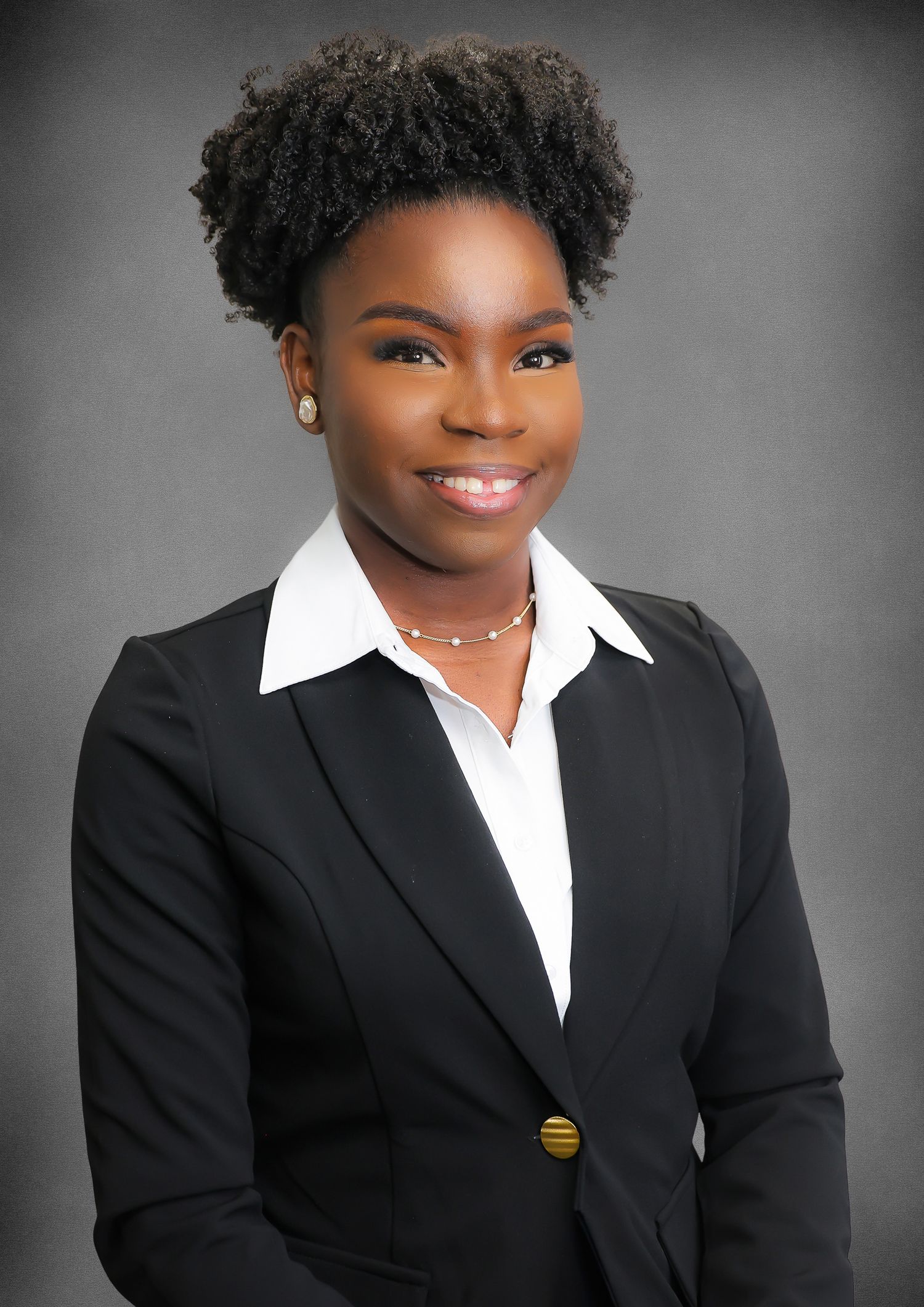 Professional studio portraits in black suits and white shirts against a gray background showing warm, engaging smiles.