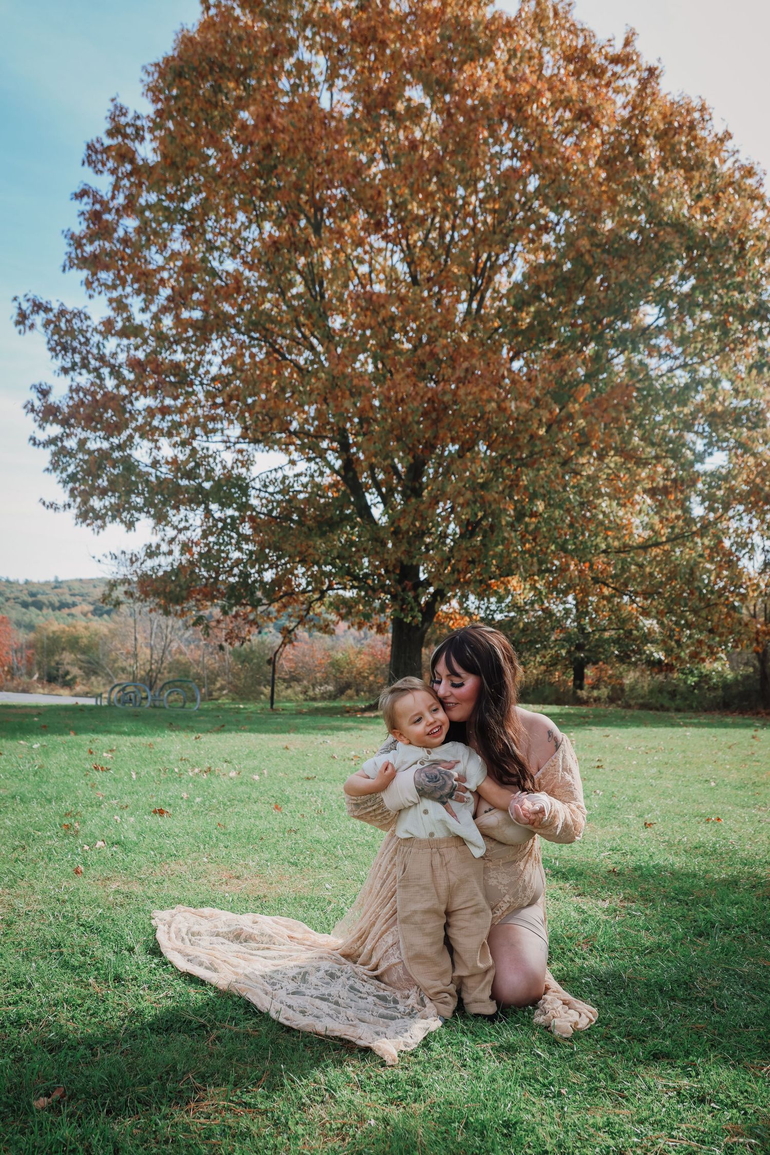 A picturesque autumn scene with a blanket laid out under colorful fall trees in a peaceful meadow setting.