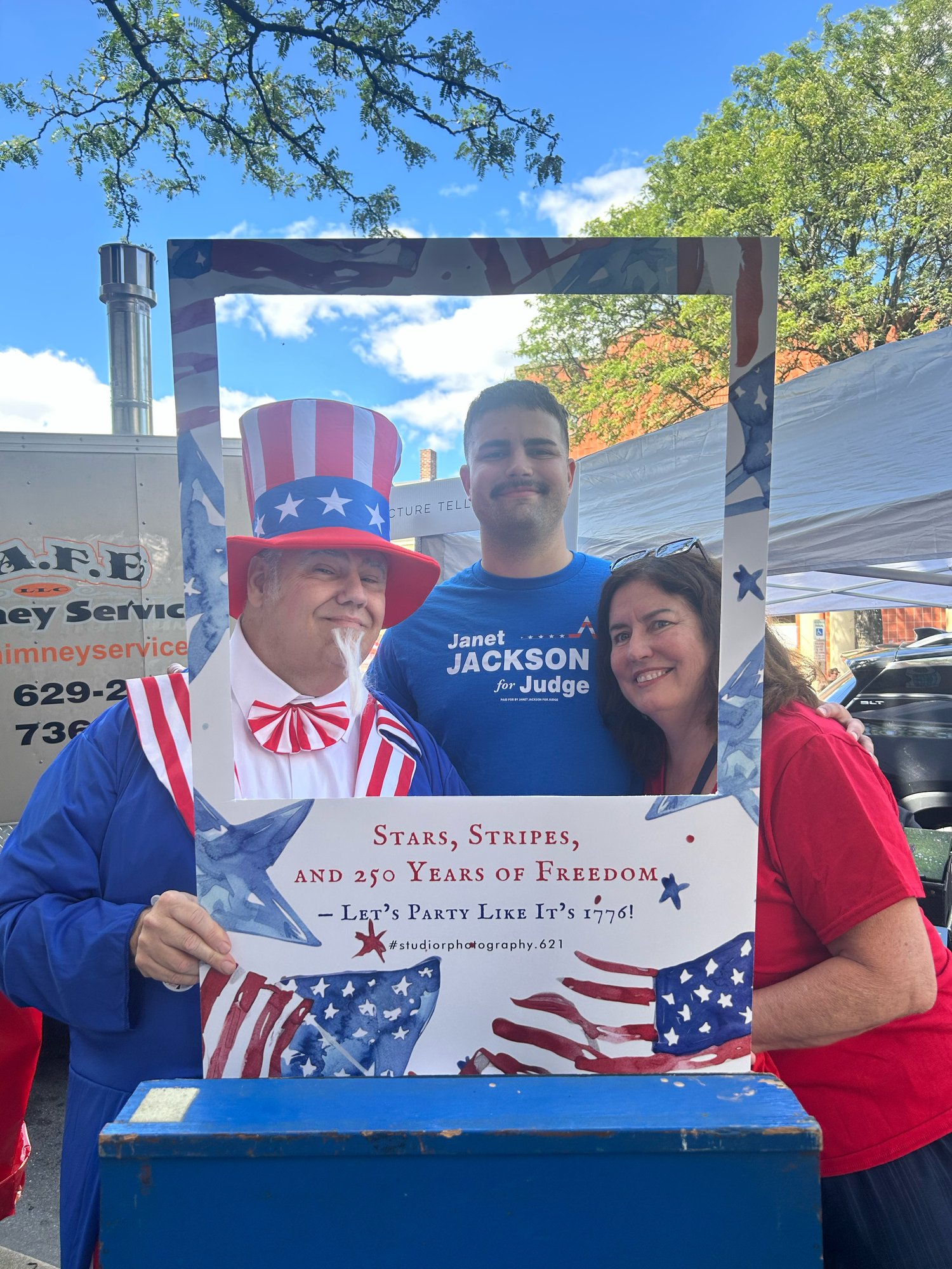 People display patriotic signs and banners at an outdoor gathering celebrating American freedom and independence.