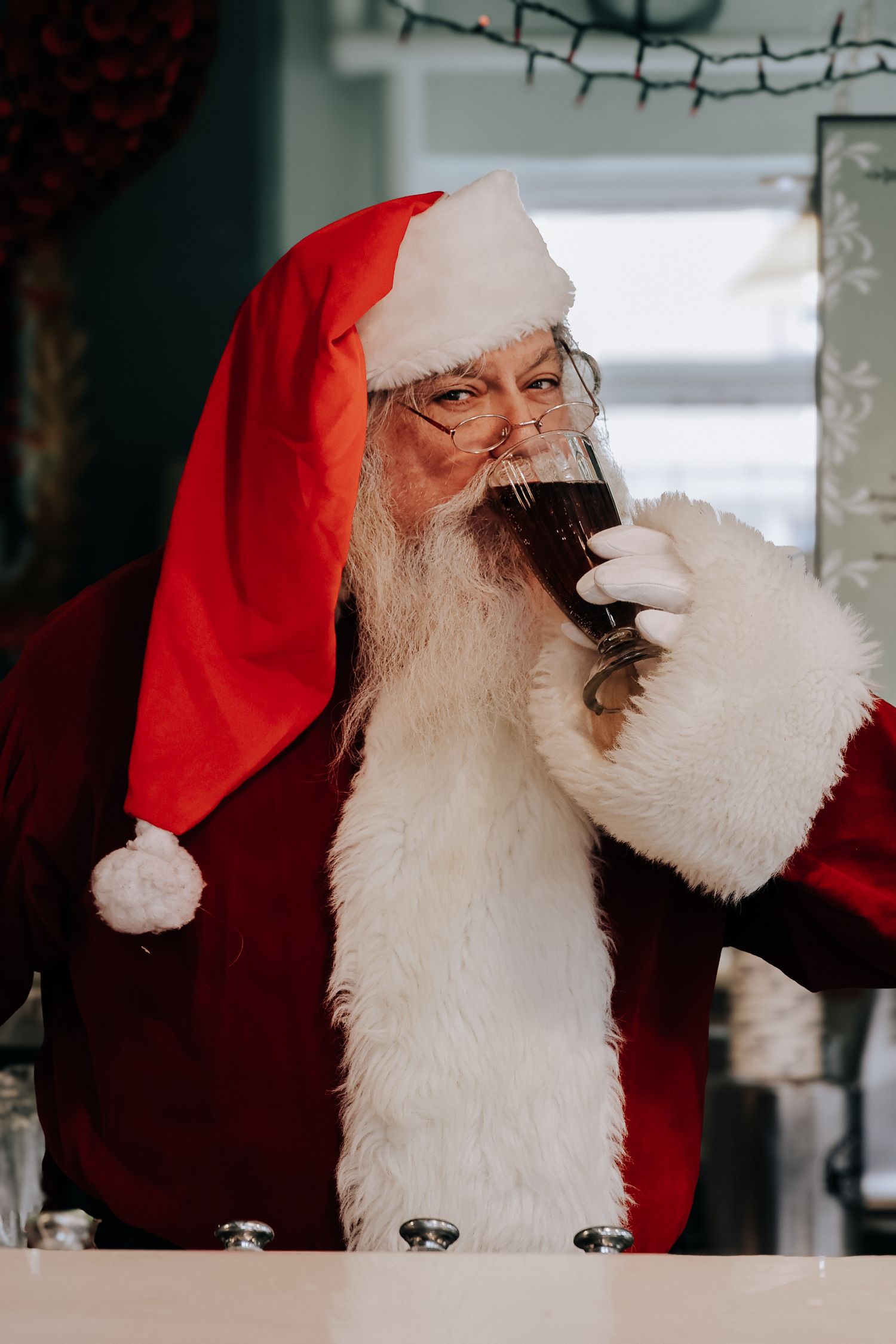 A person in a Santa suit takes a sip from a coffee mug in a sequence of progressive shots.