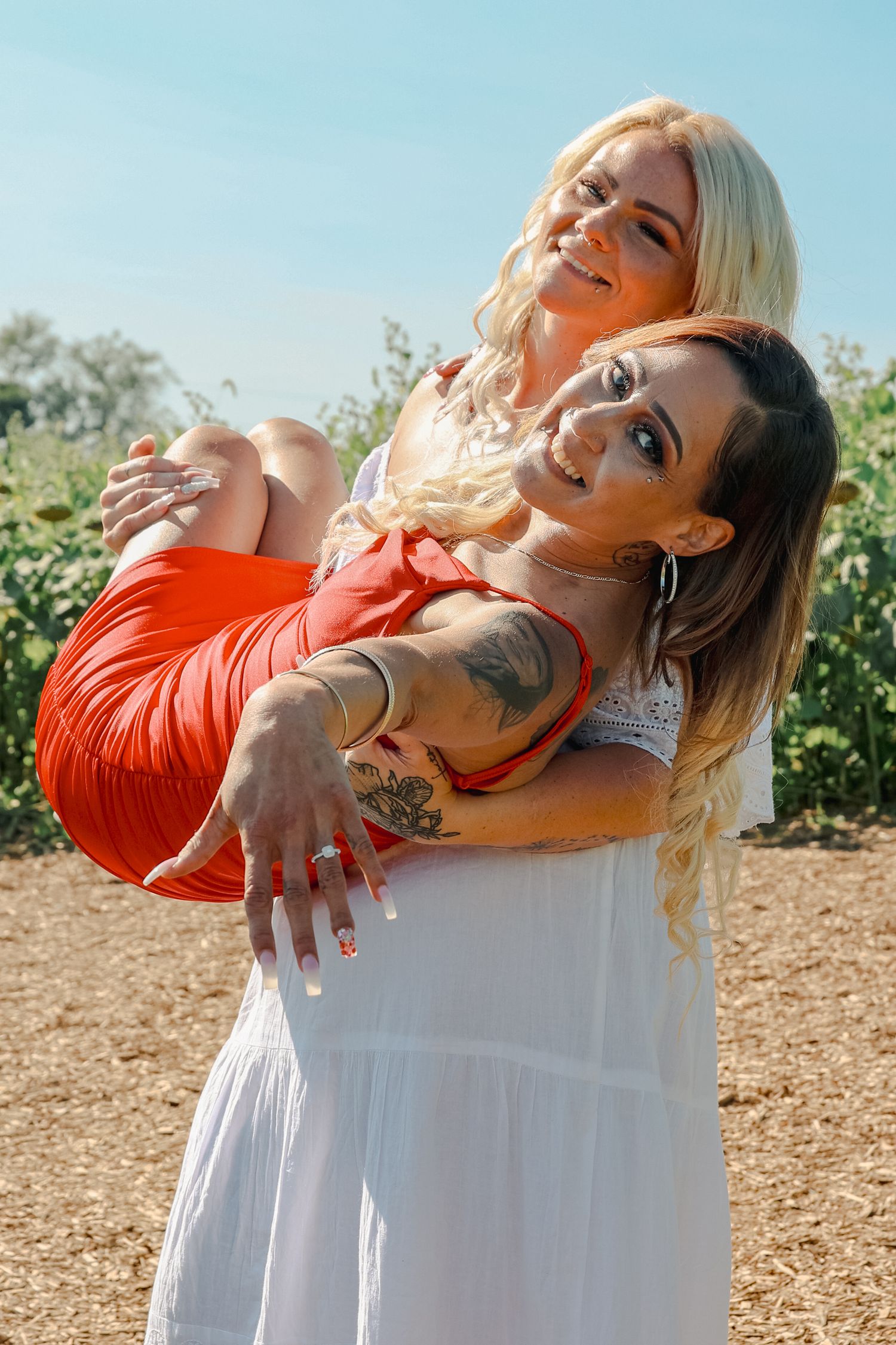 Woman in orange sweater and white dress poses dramatically against outdoor background in artistic photo series.
