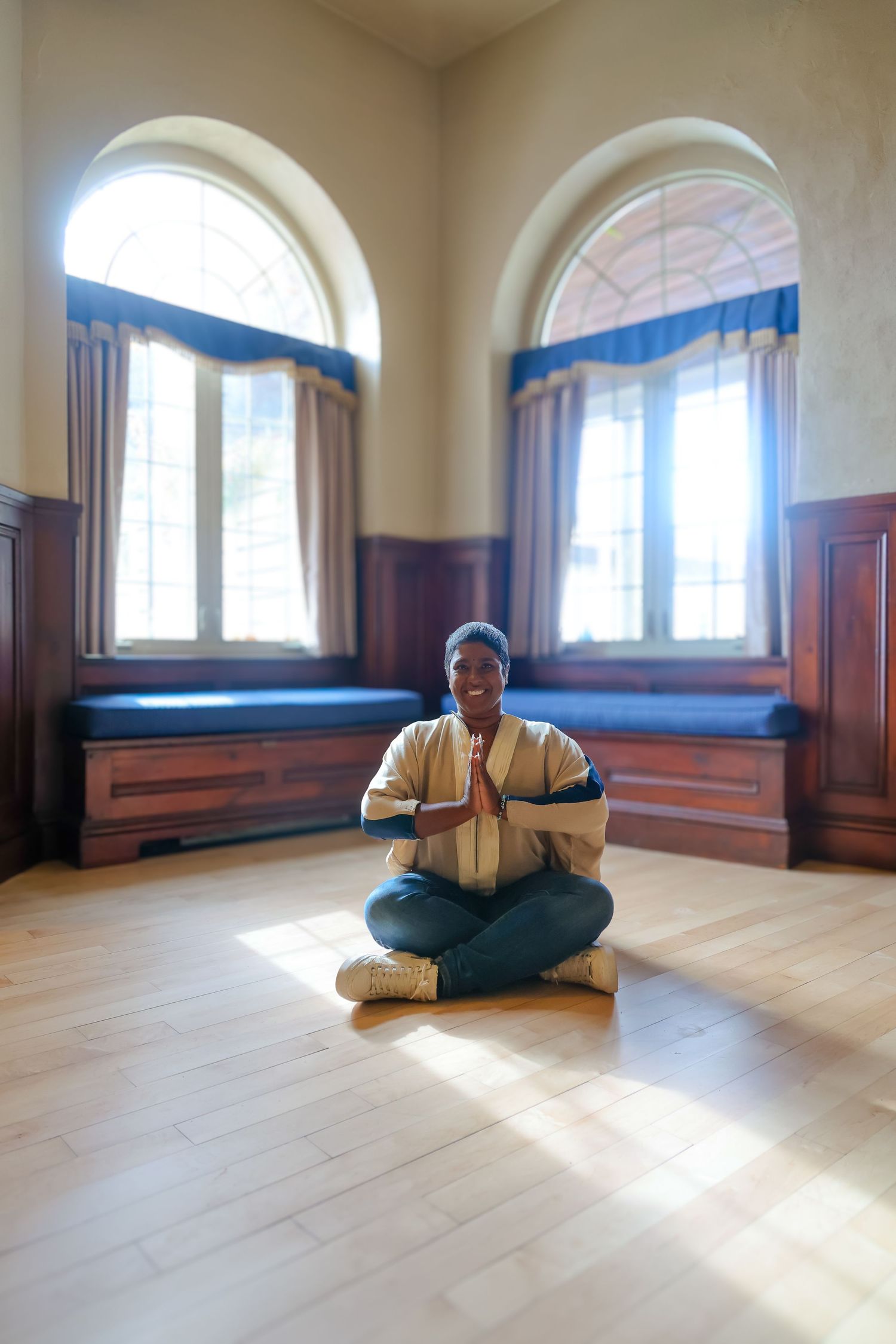 A series of photos showing a person in yoga poses sitting on a wooden floor in front of arched windows with natural light.