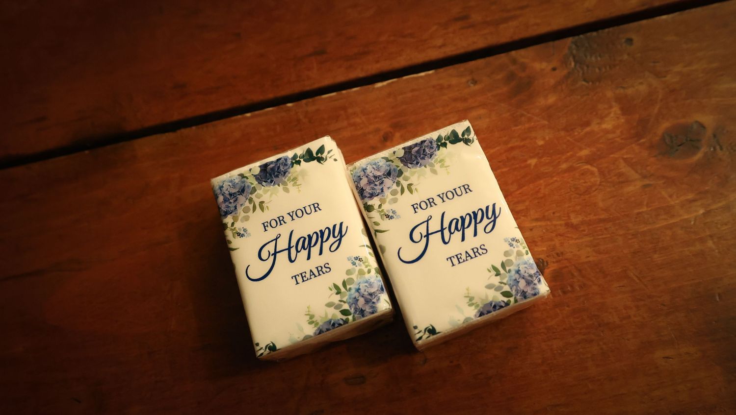 Decorative paper wrappers with 'Happy' text and floral designs displayed on a rustic wooden surface.