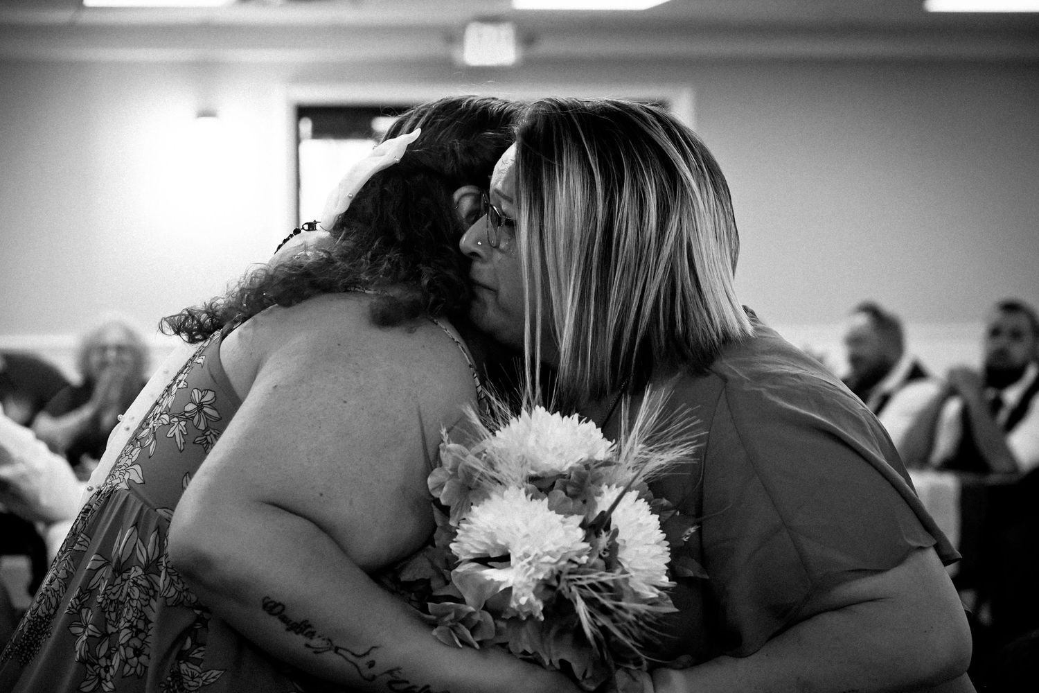 Black and white wedding photos showing intimate embraces and emotional moments during a reception celebration.